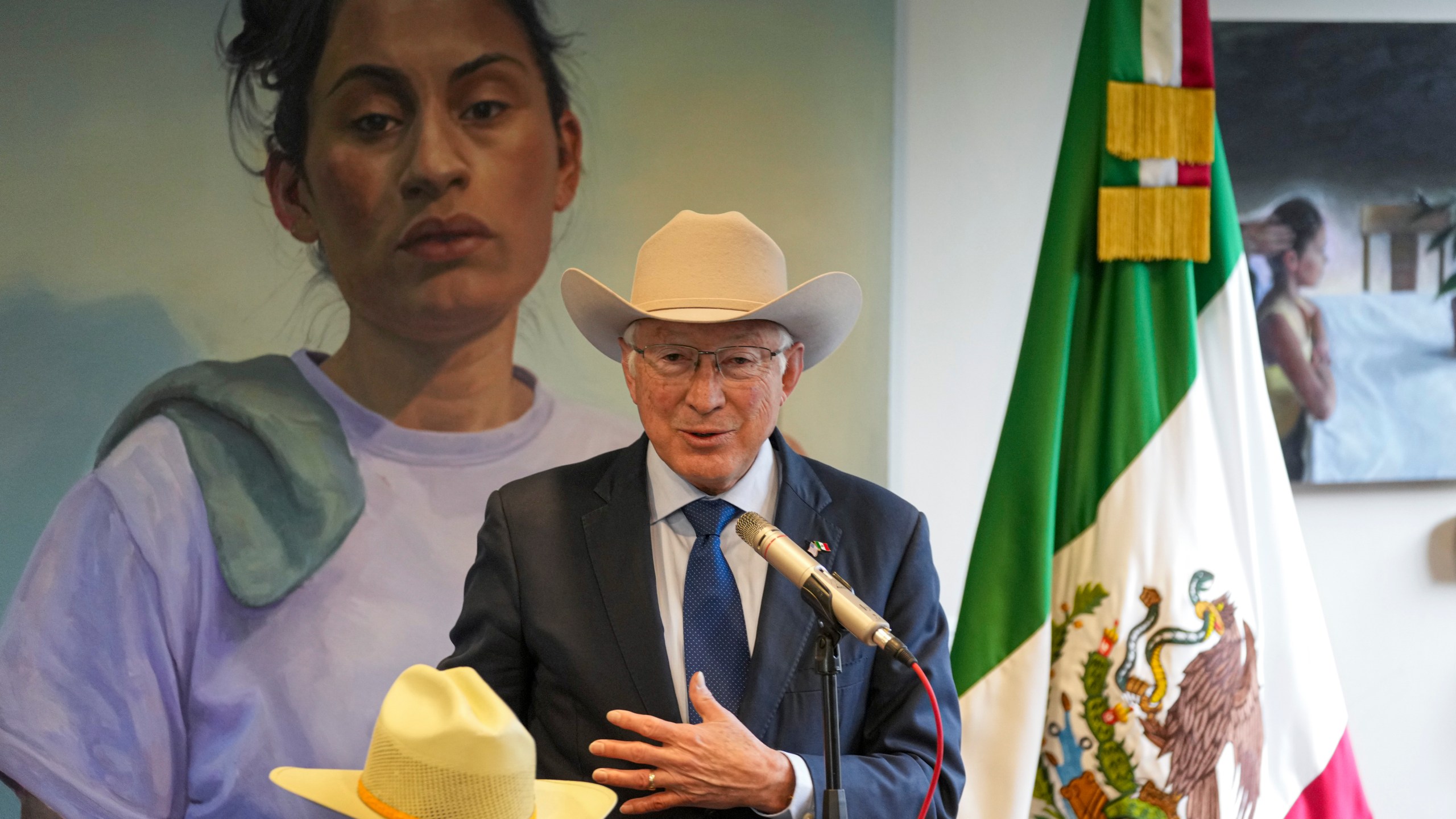 Outgoing U.S. Ambassador to Mexico Ken Salazar shows off one of his hats during the farewell news conference in Mexico City, Monday, Jan. 6, 2025. (AP Photo/Fernando Llano)