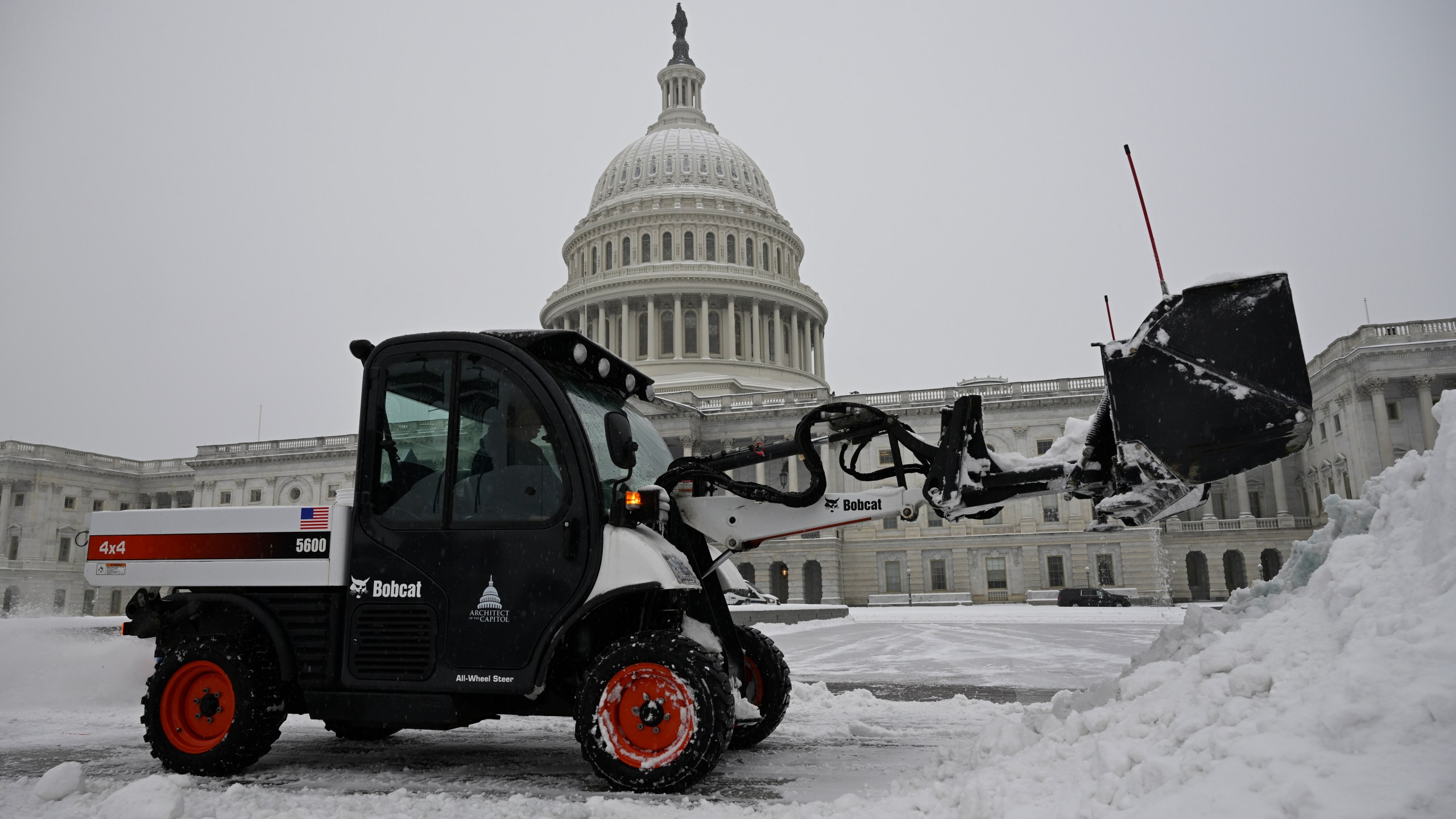 A front end loader clears a heavy early morning snow fall on the east side of the Capitol ahead of a joint session of Congress to certify the votes from the Electoral College in the presidential election, Monday, Jan. 6, 2025, in Washington. (AP Photo/John McDonnell)