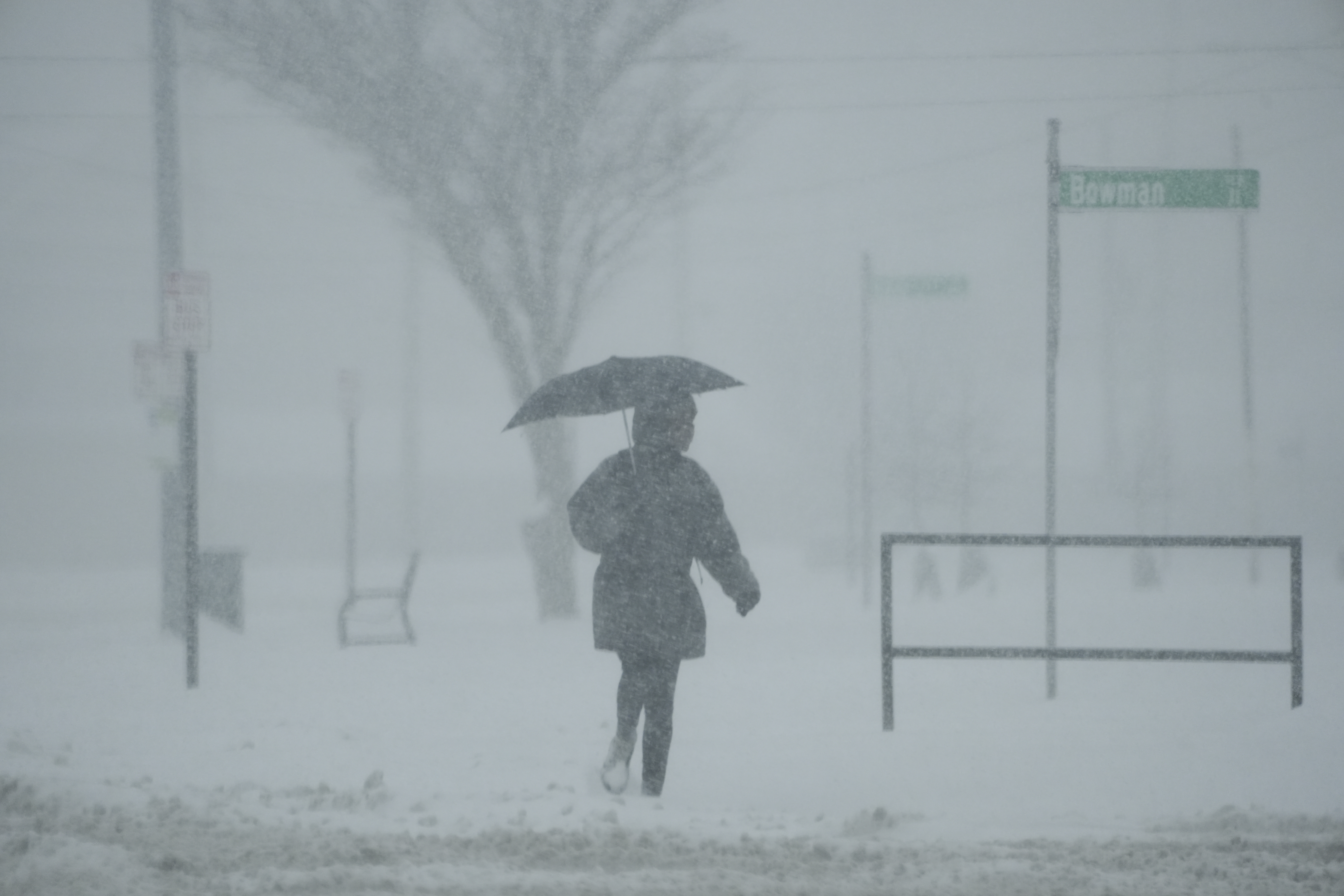 A person holds an umbrella as they walk during a winter storm, Monday, Jan. 6, 2025, in Cincinnati. (AP Photo/Joshua A. Bickel)