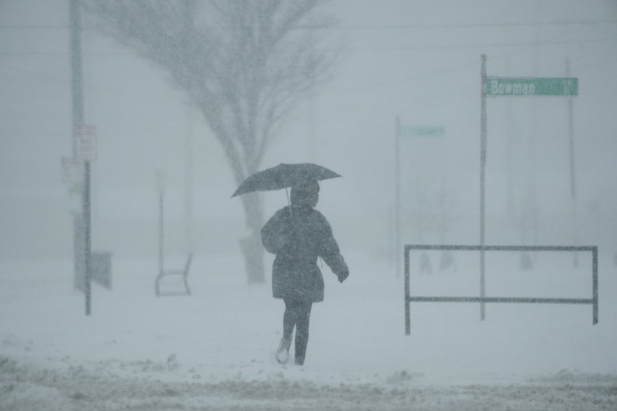 FILE - A person holds an umbrella as they walk during a winter storm, Monday, Jan. 6, 2025, in Cincinnati. (AP Photo/Joshua A. Bickel, File)