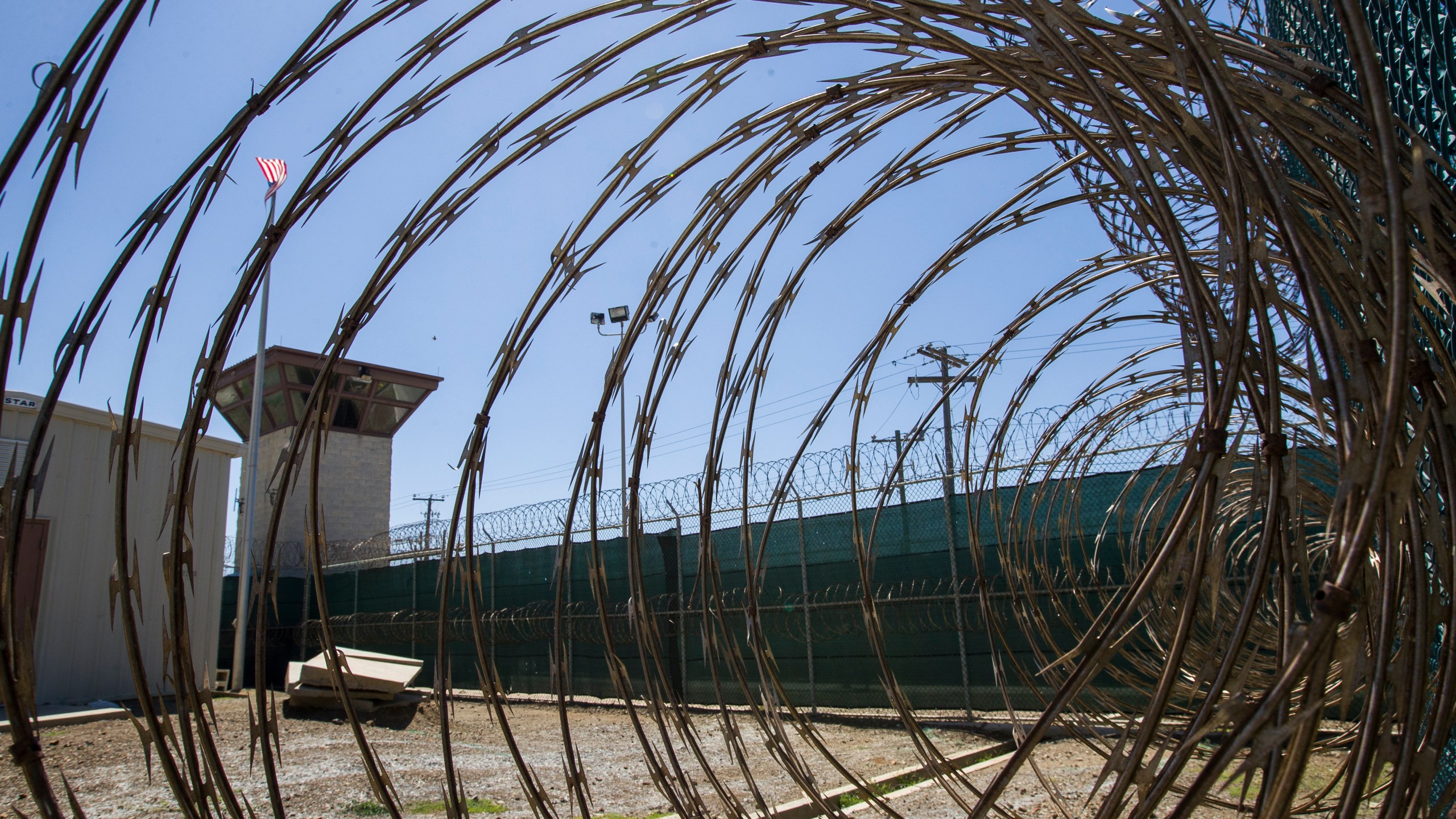 FILE - In this April 17, 2019, photo, reviewed by U.S. military officials, the control tower is seen through the razor wire inside the Camp VI detention facility in Guantanamo Bay Naval Base, Cuba. The U.S. has repatriated a Kenya man held for 17 years without charge at the U.S. military prison in Guantanamo Bay, Cuba. The move leaves 15 other men still waiting for release from Guantanamo after being cleared of wrongdoing after long detentions. (AP Photo/Alex Brandon, File)