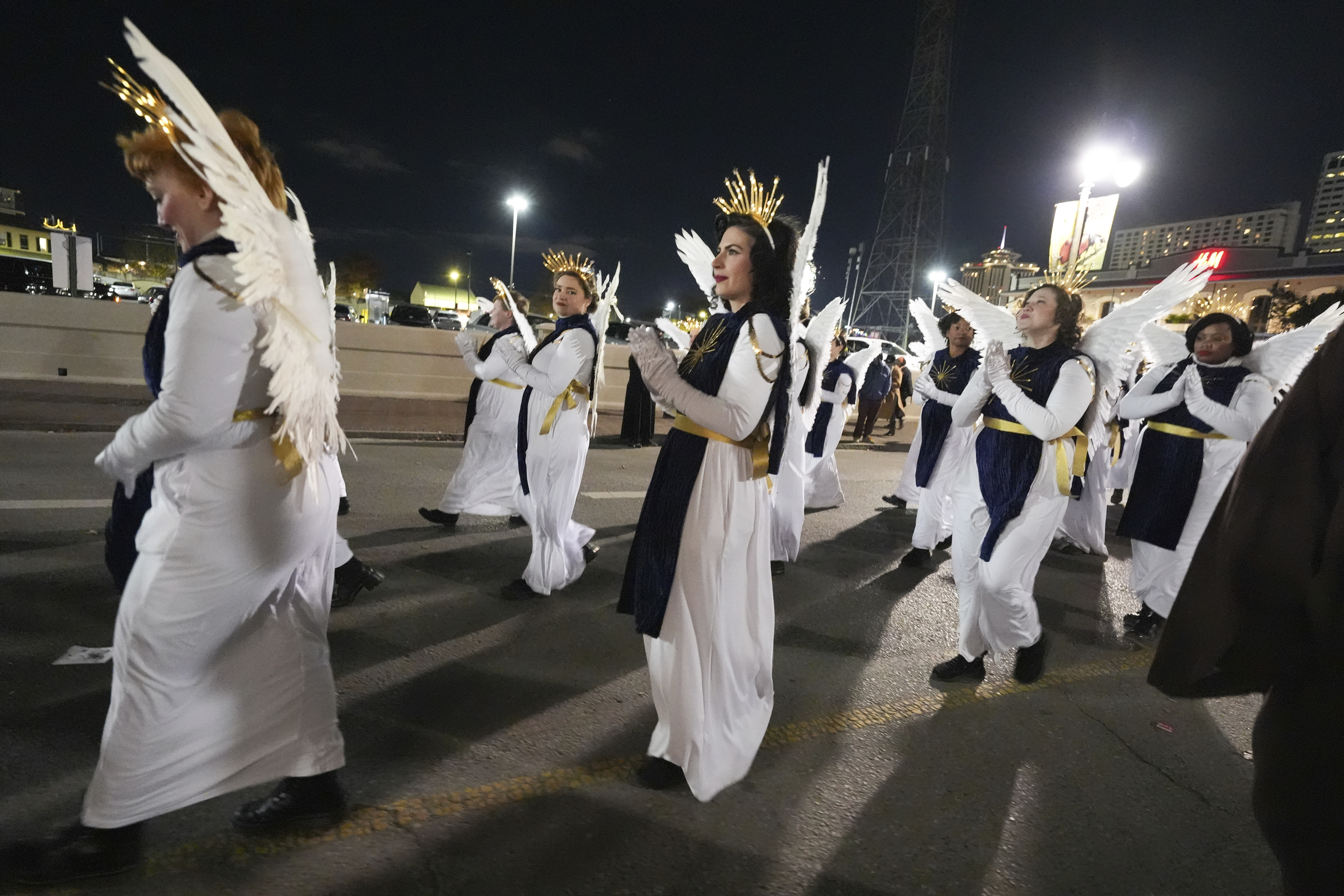 Parade-goers dressed as angels walk during the annual Krewe de Jeanne d'Arc parade, kicking off the Mardi Gras season, in New Orleans, Monday, Jan. 6, 2025. (AP Photo/Gerald Herbert)