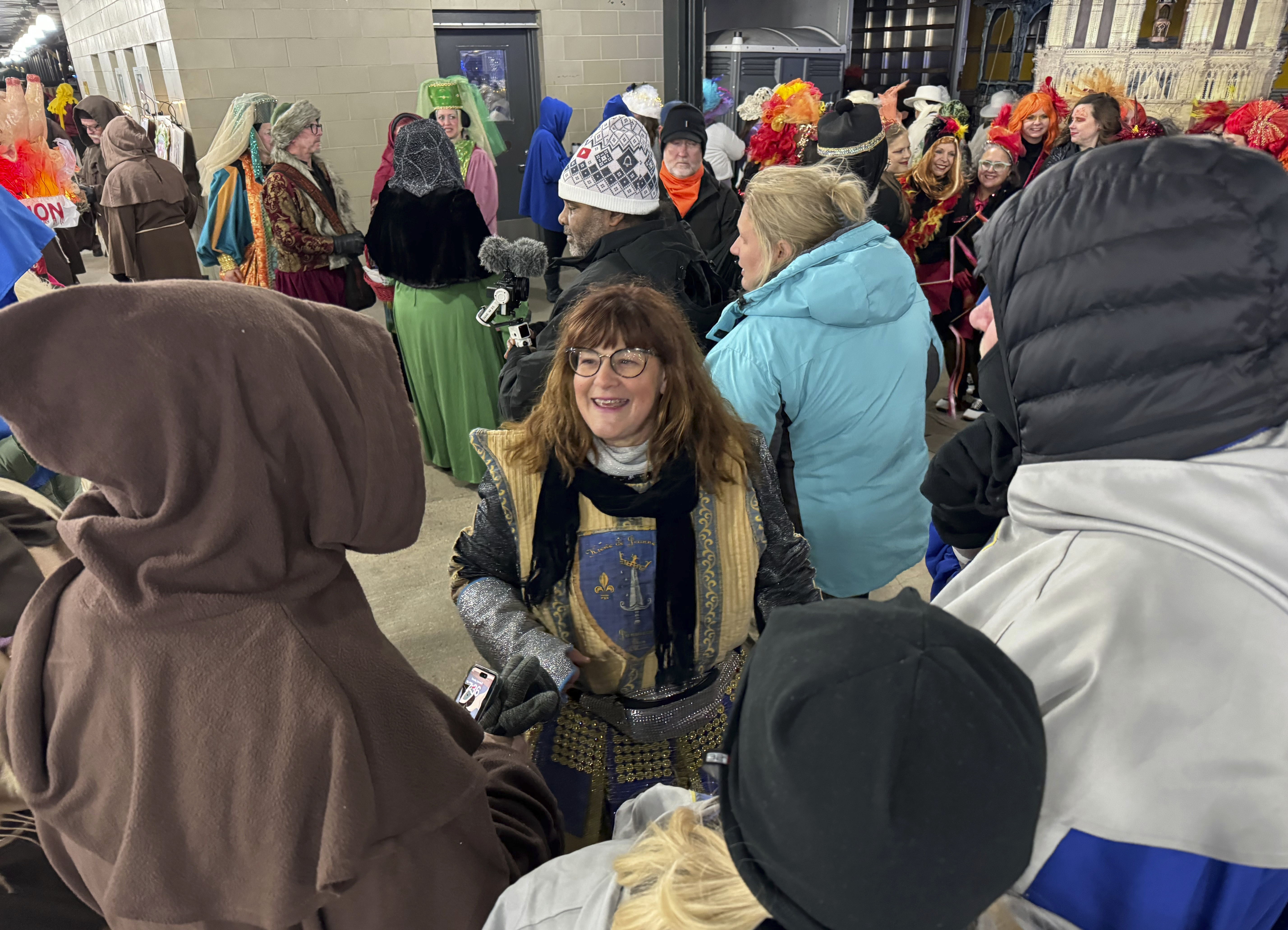 Antoinette de Alteriis, co-captain of the Krewe de Jeanne d'Arc, organizes volunteers before the start of the Joan of Arc parade on Monday, Jan. 6, 2025, in New Orleans. (AP Photo/Jack Brook)