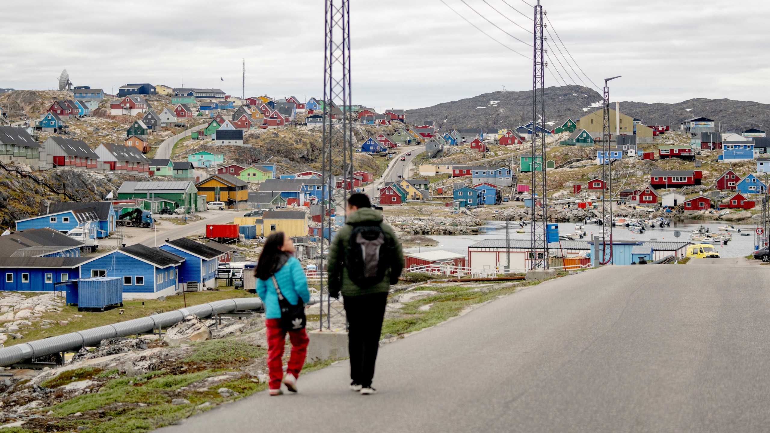 FILE - People walk in the town of Aasiaat, in western Greenland, located on its namesake island in the heart of Aasiaat Archipelago at the southern end of Disko Bay, in Greenland, Saturday, June 29, 2024. (Ida Marie Odgaard/Ritzau Scanpix via AP, File)