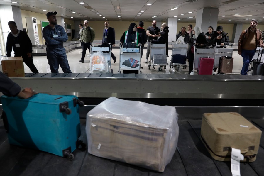 Passengers who arrived at a first international commercial flight since the fall of former Syrian President Bashar Assad, wait to receive their luggages at the arrival terminal of Damascus international airport, in Damascus, Syria, Tuesday, Jan. 7, 2025. (AP Photo/Omar Sanadiki)