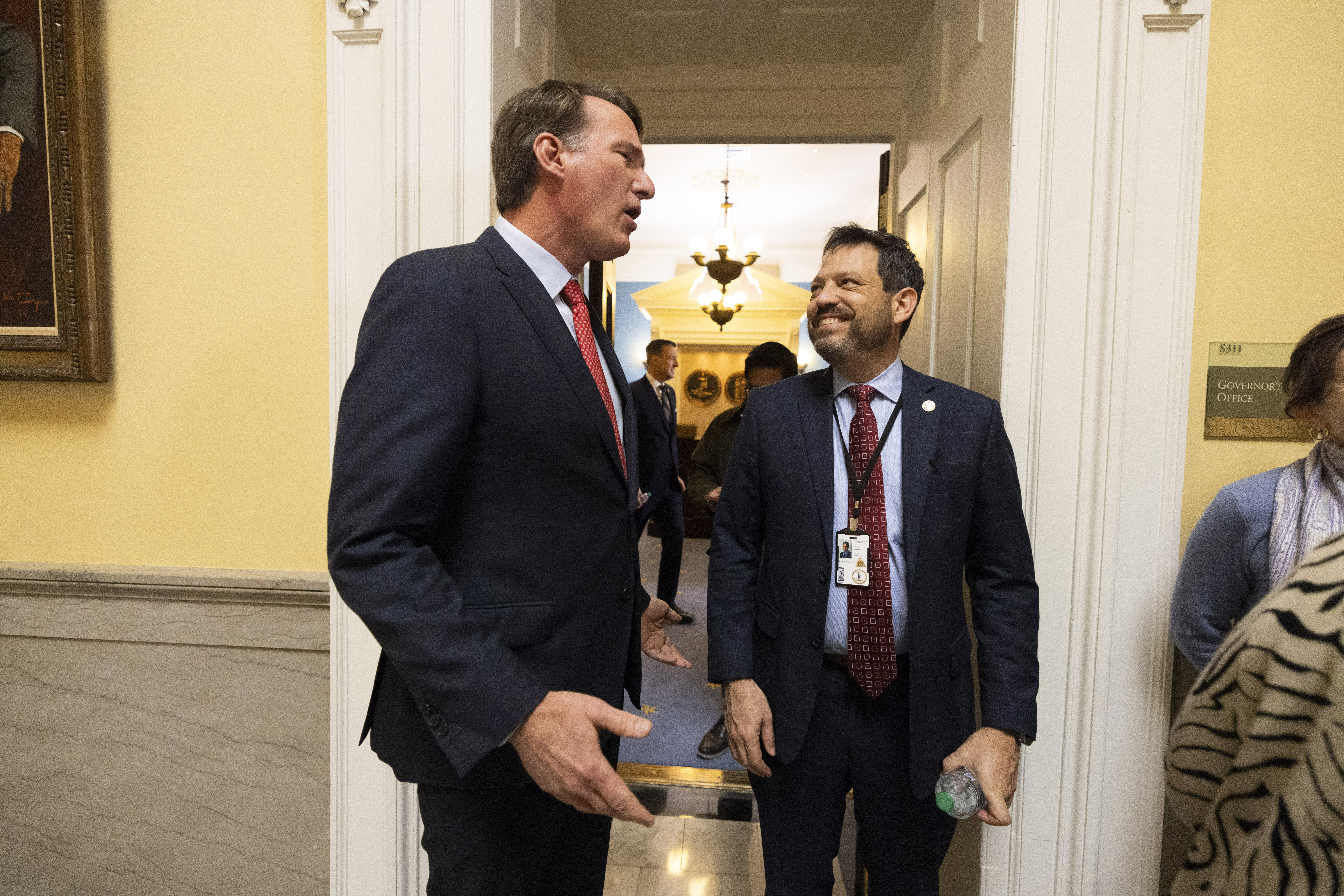 Virginia Gov. Glenn Youngkin, left, speaks to state Sen. Scott Surovell, D-Fairfax on the first day of the legislative session, Wednesday, Jan. 8, 2025, in Richmond, Va. (Mike Kropf/Richmond Times-Dispatch via AP)