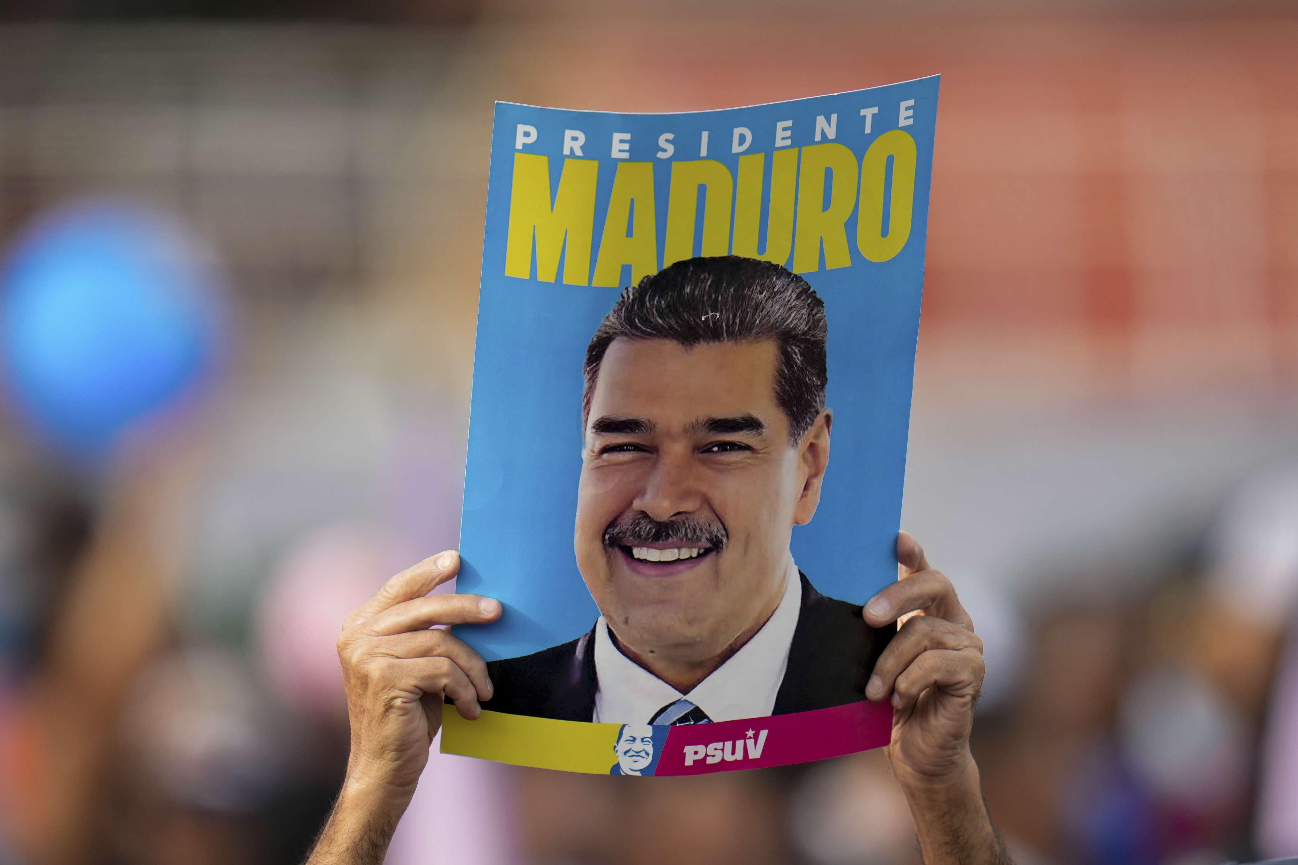 FILE - A supporter displays a poster of President Nicolas Maduro during his closing election campaign rally in Caracas, Venezuela, July 25, 2024. (AP Photo/Fernando Vergara, File)