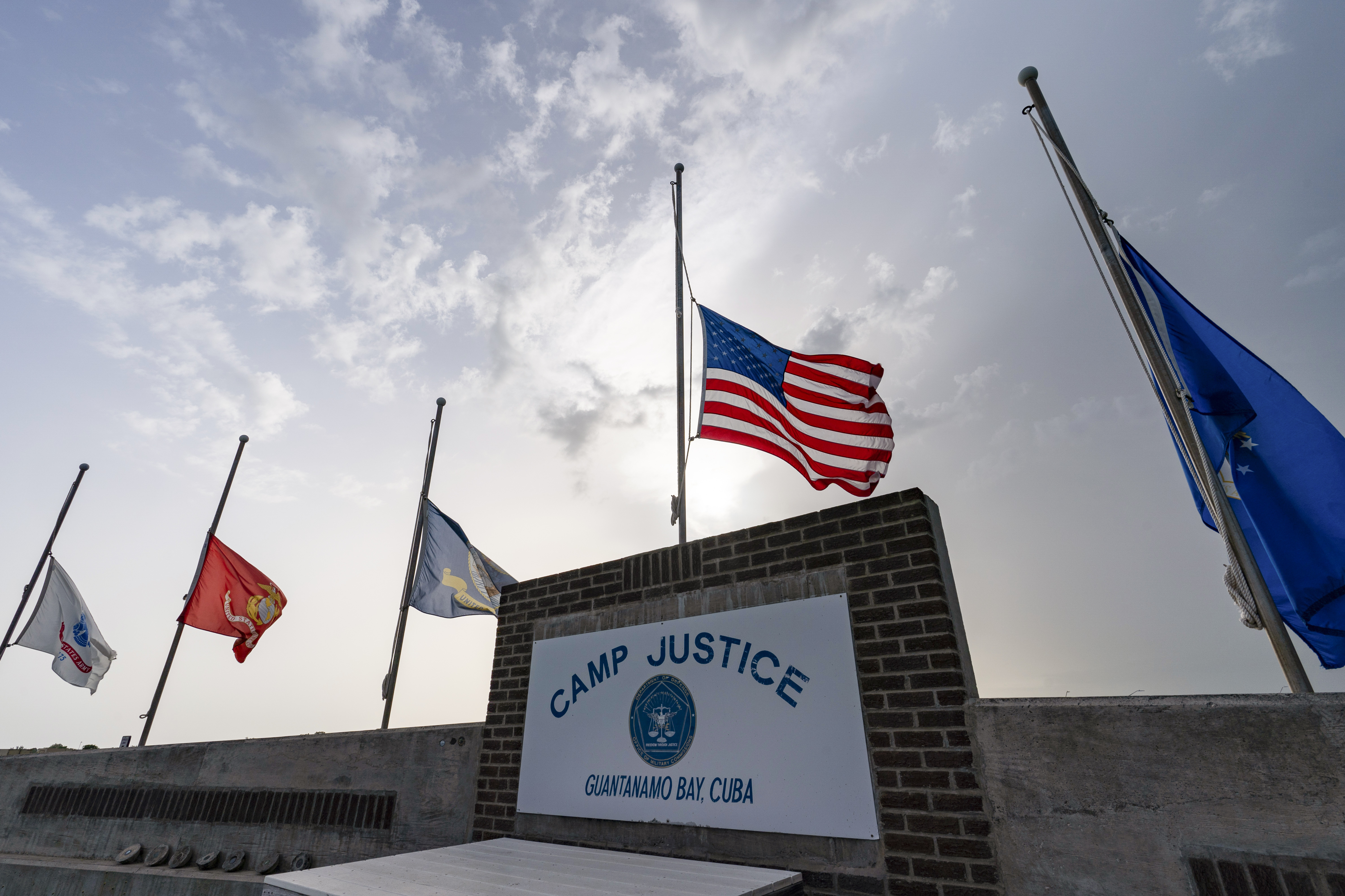 FILE - In this photo reviewed by U.S. military officials, flags fly at half-staff at Camp Justice, Aug. 29, 2021, in Guantanamo Bay Naval Base, Cuba. (AP Photo/Alex Brandon, File)