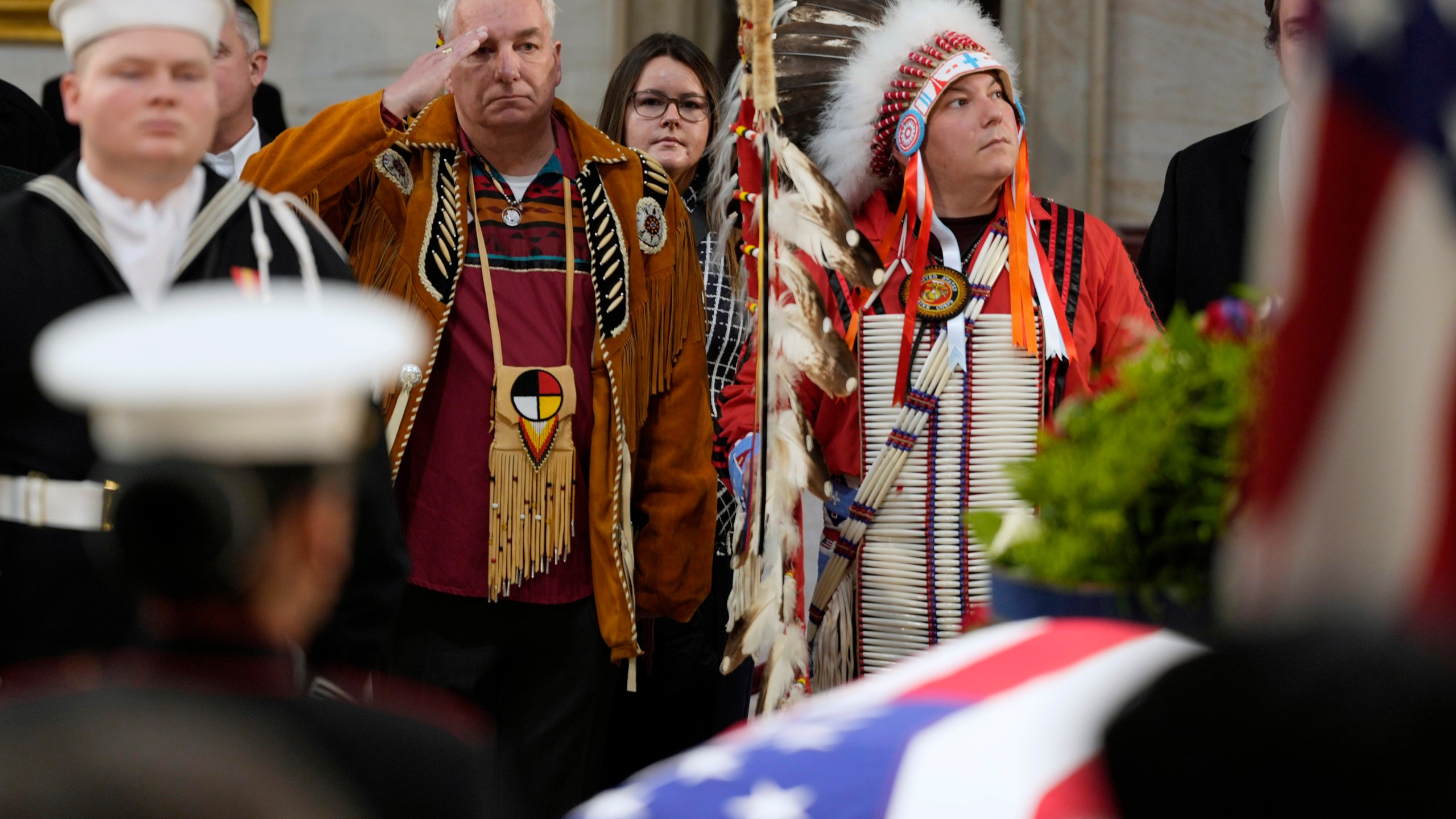 Army veteran Donald Woody, left, and Marine veteran Warren Stade, in eagle feather bonnet, pay their respects as former President Jimmy Carter lies in state at the U.S. Capitol, Wednesday, Jan. 8, 2025, in Washington. Carter died Dec. 29 at the age of 100. The two are from the Skakopee Mdewakanton Sioux Community in Prior Lake, Minn. (AP Photo/Steve Helber)