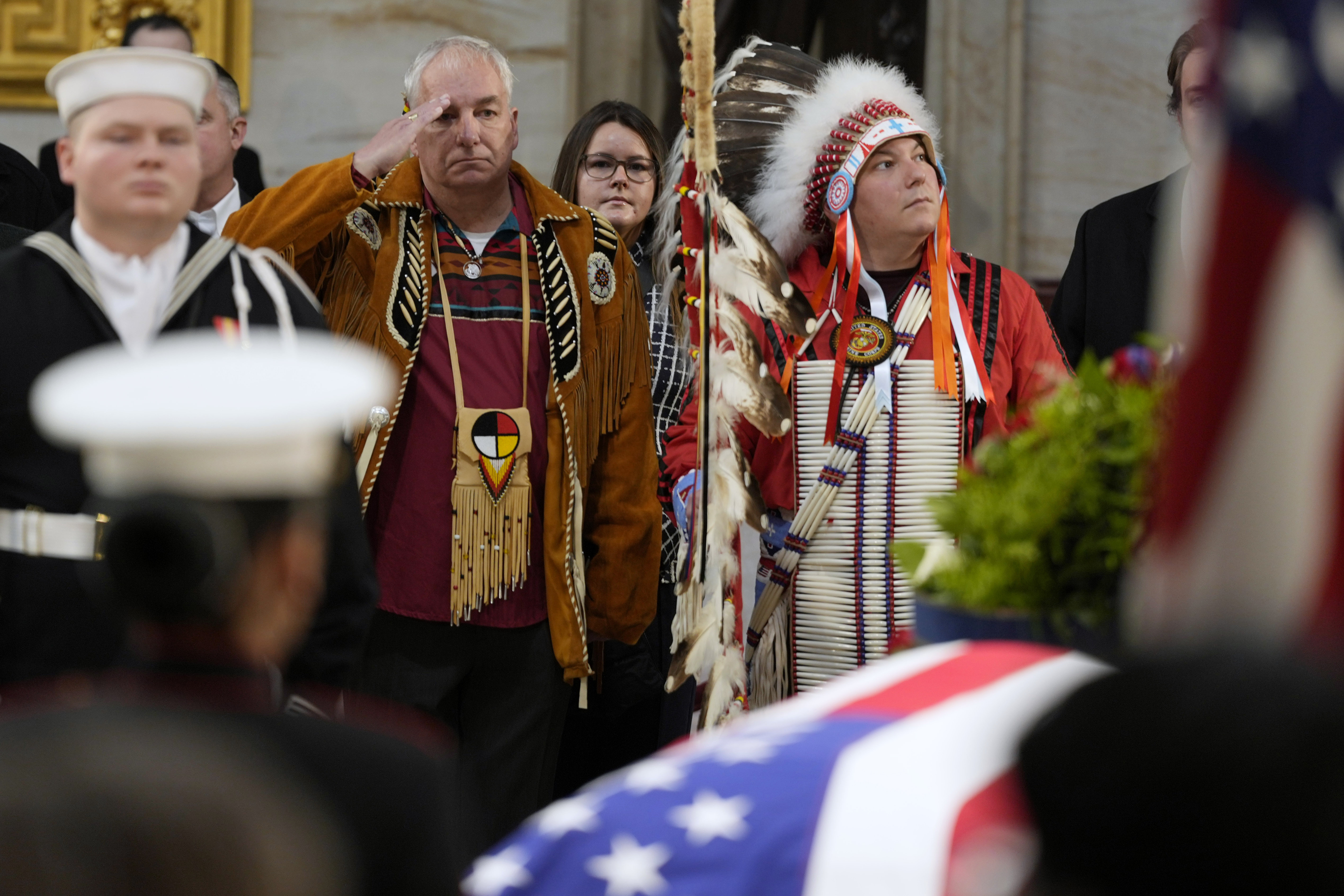 Army veteran Donald Woody, left, and Marine veteran Warren Stade, in eagle feather bonnet, pay their respects as former President Jimmy Carter lies in state at the U.S. Capitol, Wednesday, Jan. 8, 2025, in Washington. Carter died Dec. 29 at the age of 100. The two are from the Skakopee Mdewakanton Sioux Community in Prior Lake, Minn. (AP Photo/Steve Helber)