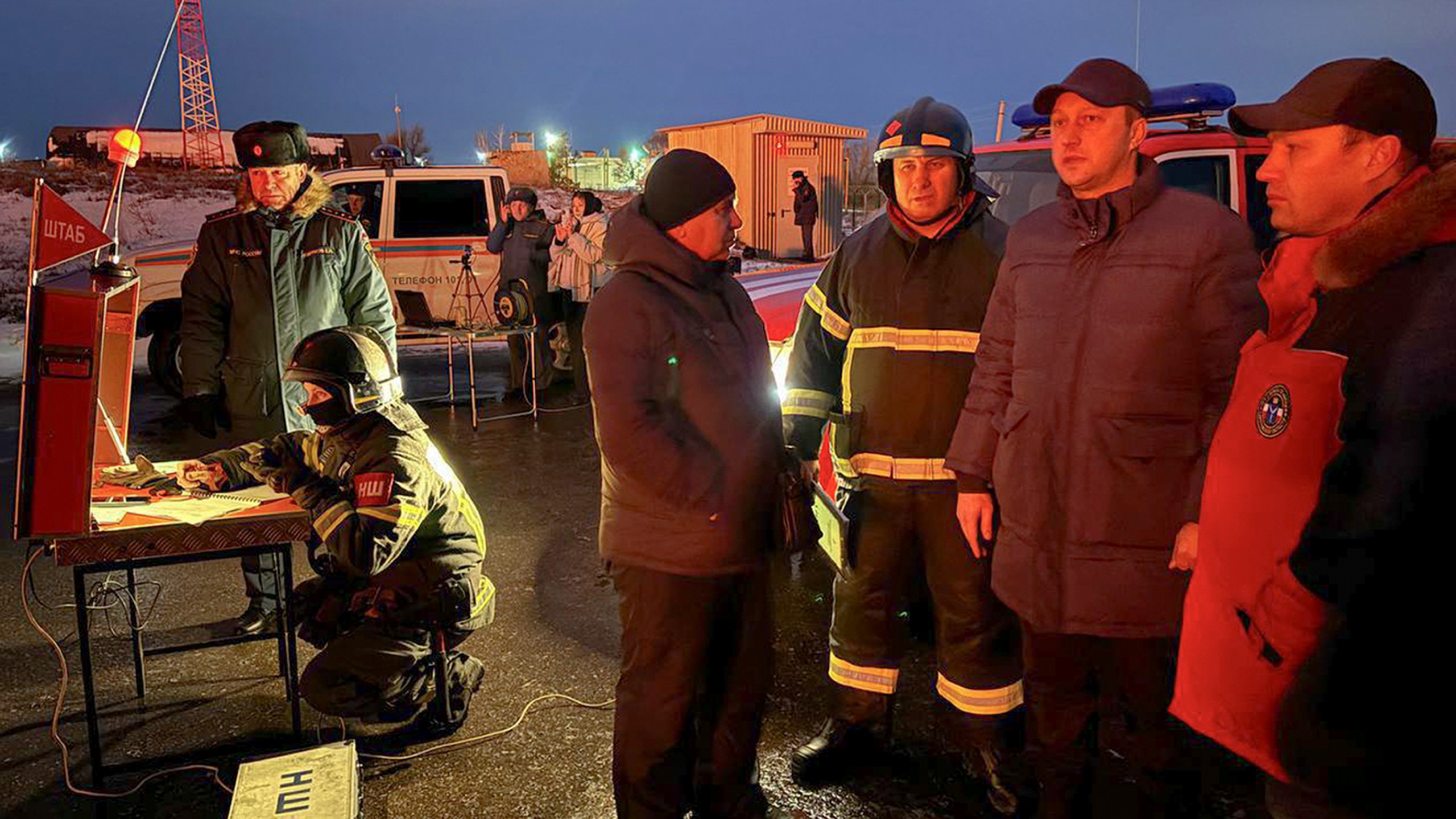 In this photo released by Governor of the Saratov region Roman Busargin telegram channel on Wednesday, Jan. 8, 2025, Governor of the Saratov region Roman Busargin, second right, speaks to firefighters and rescuers at the industrial side damaged after Ukrainian drones' attack in Saratov, Russia. (Governor of the Saratov region Roman Busargin telegram channel via AP)