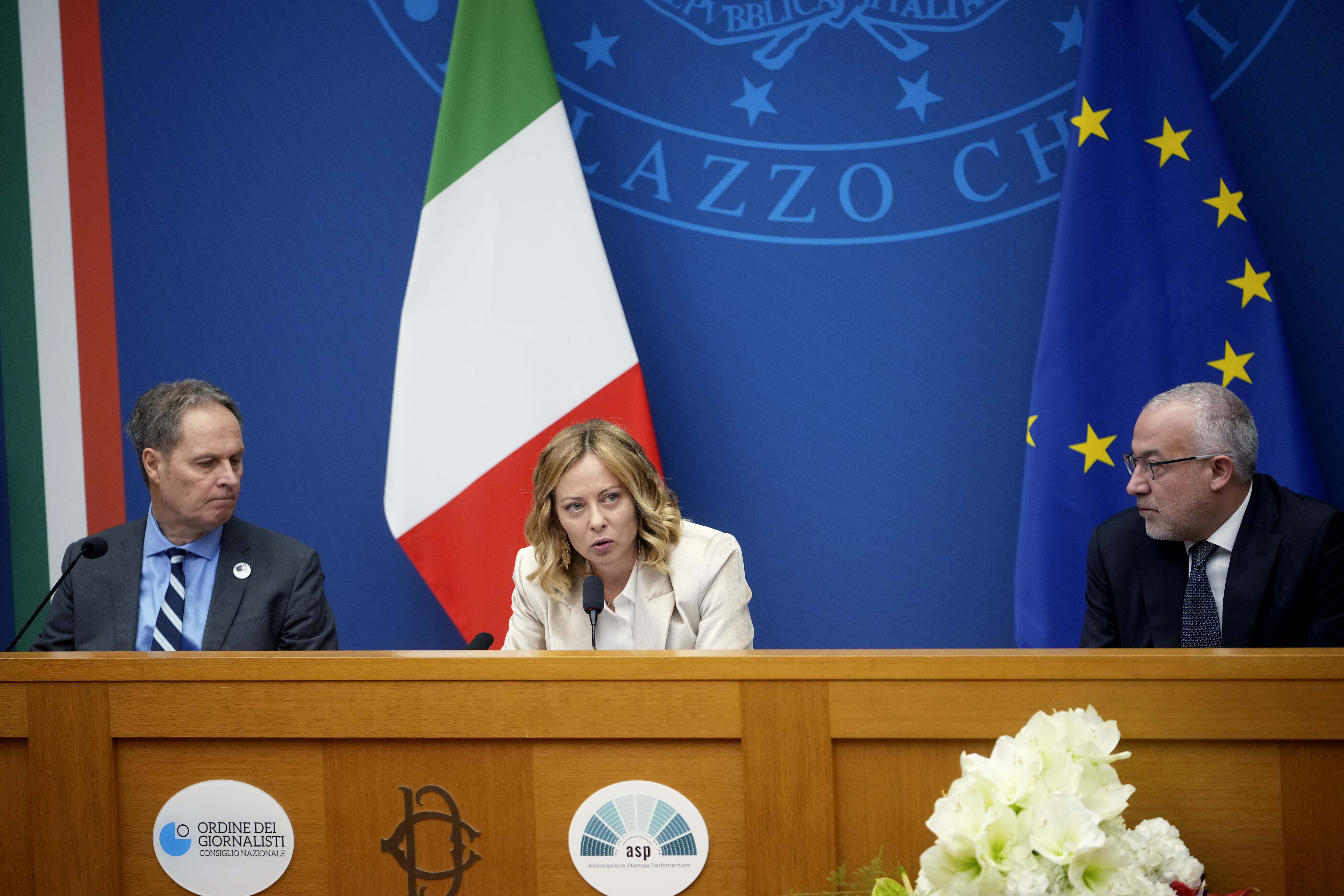 Italian Premier Giorgia Meloni holds the 2024 year-end press conference, flanked by the Italian president of the Order of Journalists, Carlo Bartoli, left, and Italian national press federation president Vittorio Di Trapani, in Rome, Thursday, Jan. 9, 2025. (AP Photo/Alessandra Tarantino)