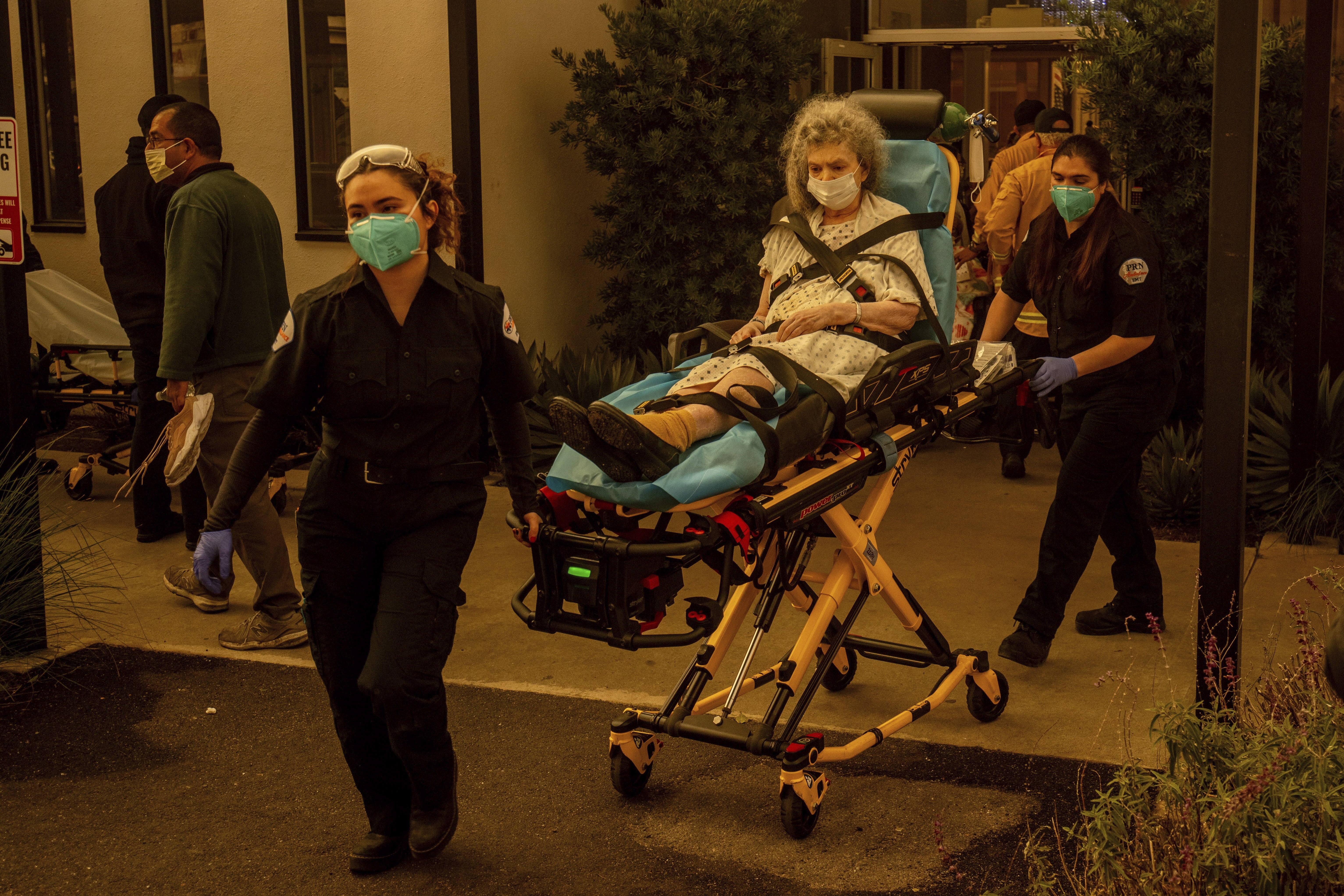 A resident is evacuated from a senior living facility as the Eaton Fire approaches Wednesday, Jan. 8, 2025, in Altadena, Calif. (AP Photo/Ethan Swope)