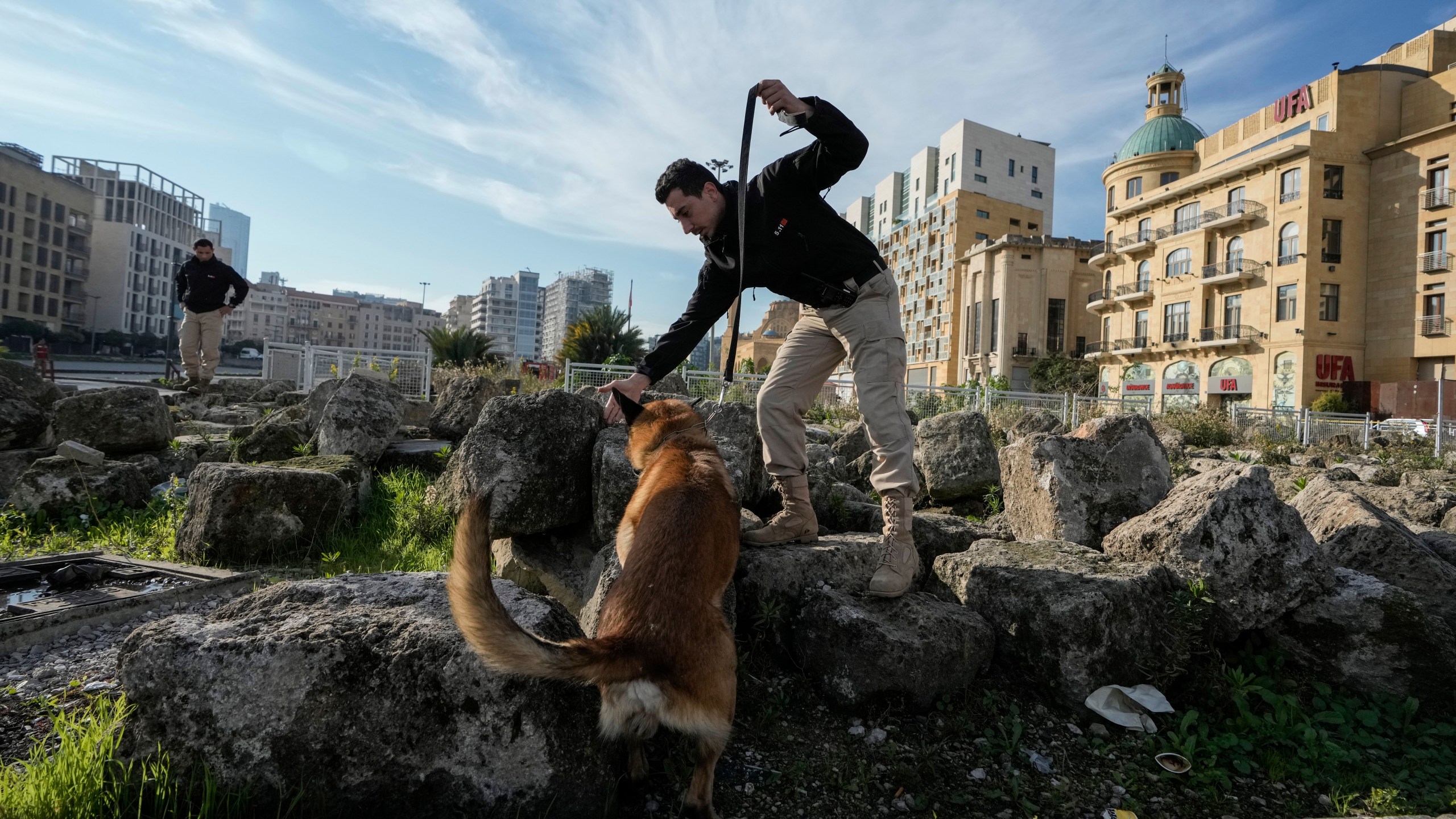 A Lebanese army soldier with a sniffer dog checks a road that leads to the parliament building while lawmakers gather to elect a president in Beirut, Lebanon, Thursday, Jan. 9, 2025. (AP Photo/Bilal Hussein)