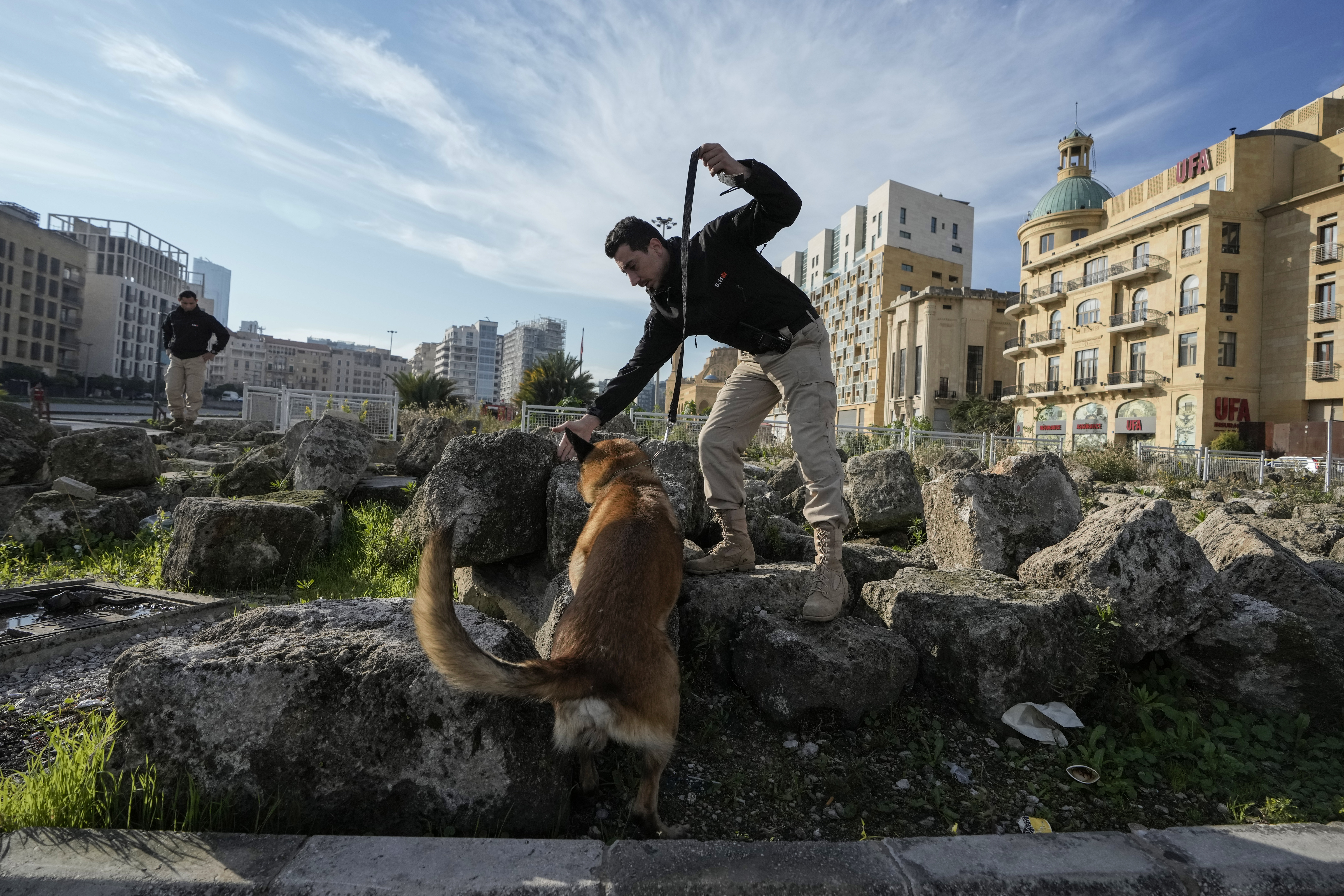 A Lebanese army soldier with a sniffer dog checks a road that leads to the parliament building while lawmakers gather to elect a president in Beirut, Lebanon, Thursday, Jan. 9, 2025. (AP Photo/Bilal Hussein)