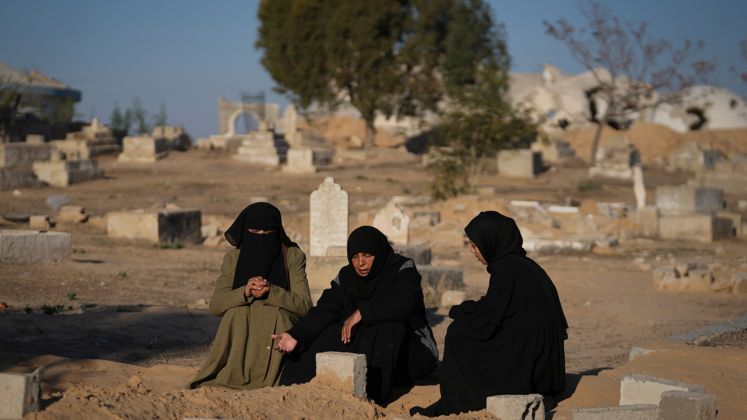 Fatma Abu Awad and her daughter Malak pray in a graveyard where their relatives who were killed by an Israeli airstrike are buried, in Khan Younis, Gaza, Thursday, Jan. 9, 2025. (AP Photo/Abdel Kareem Hana)