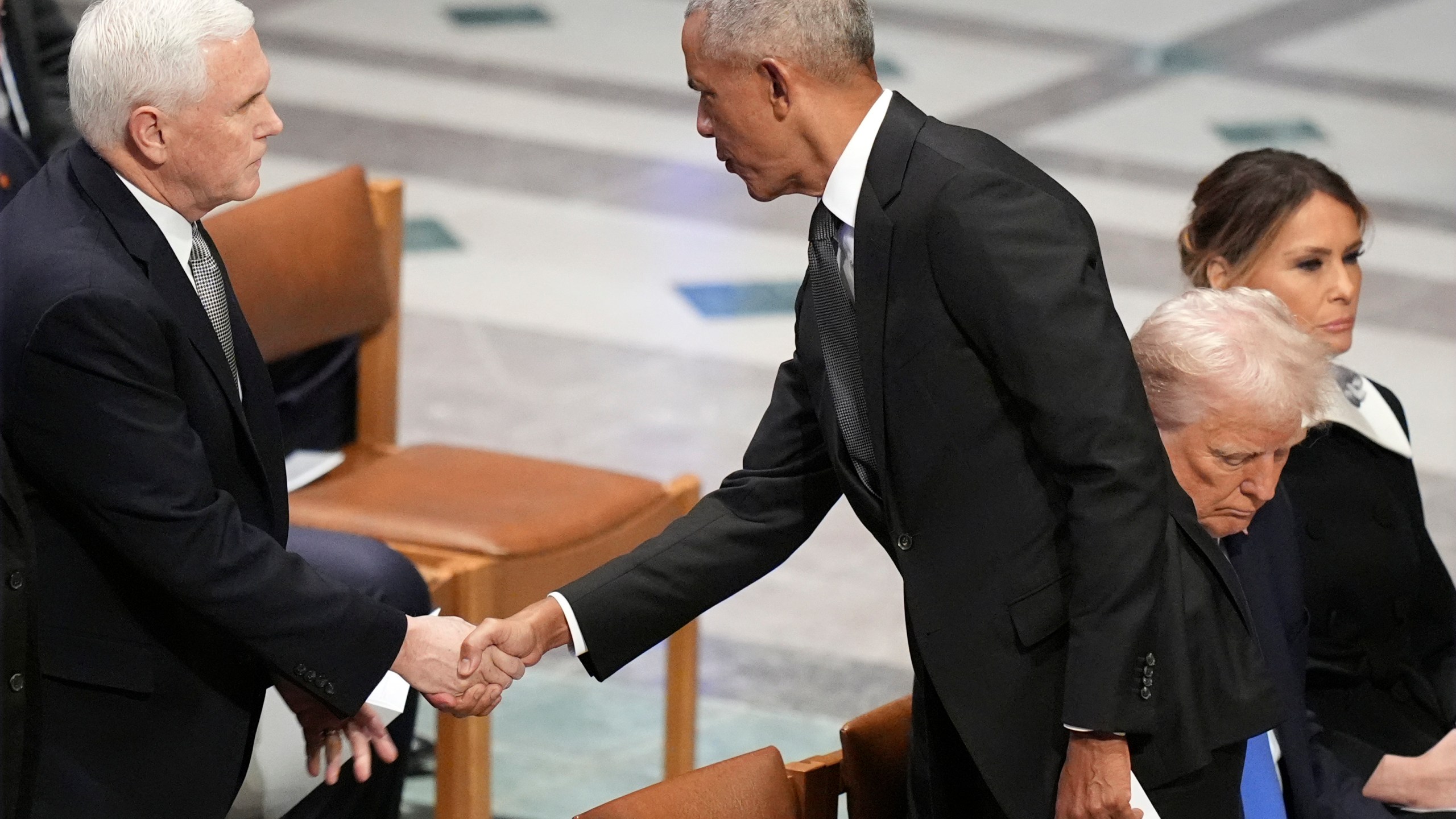 Former President Barack Obama shakes hands with former Vice President Mike Pence before the state funeral for former President Jimmy Carter at Washington National Cathedral in Washington, Thursday, Jan. 9, 2025, as President-elect Donald Trump sits with Melania Trump at right. (AP Photo/Jacquelyn Martin)