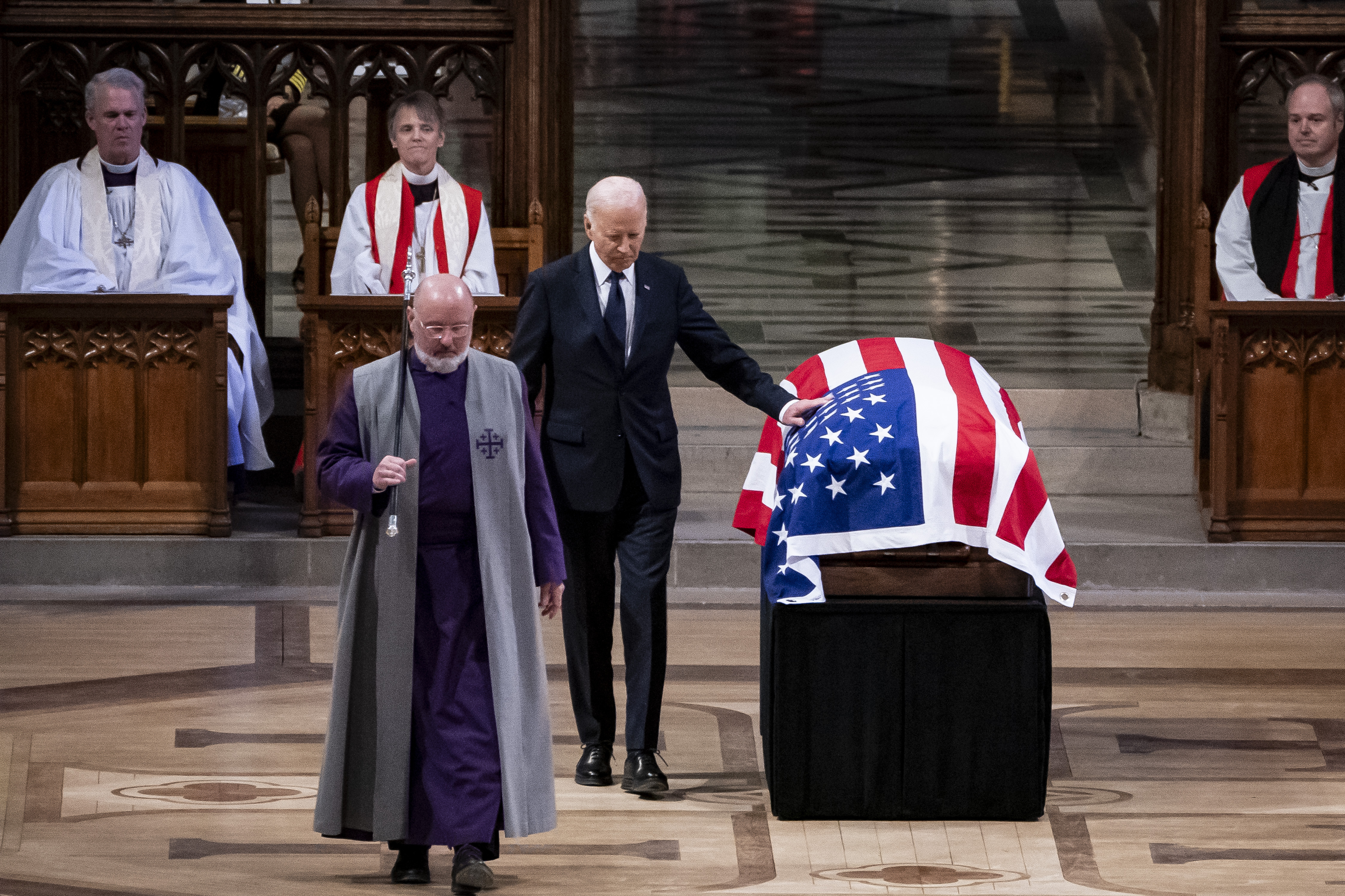 President Joe Biden touches the casket of former President Jimmy Carter after delivering remarks during Carter's state funeral at the National Cathedral, Thursday, Jan. 9, 2025, in Washington. (Haiyun Jiang/The New York Times via AP, Pool)