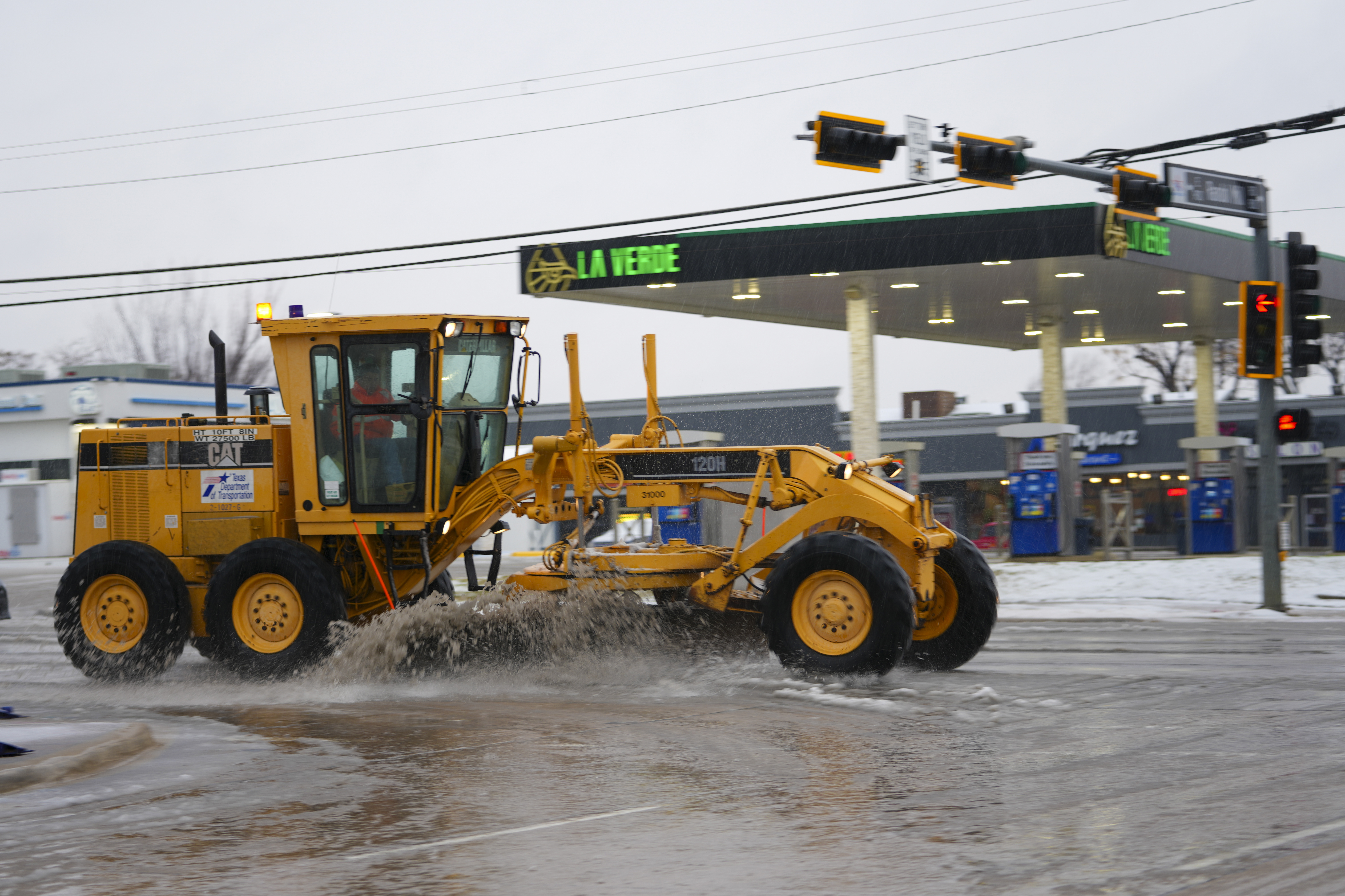 Slush is plowed on a street during a winter storm, Thursday, Jan. 9, 2025, in Arlington, Texas. (AP Photo/Julio Cortez)