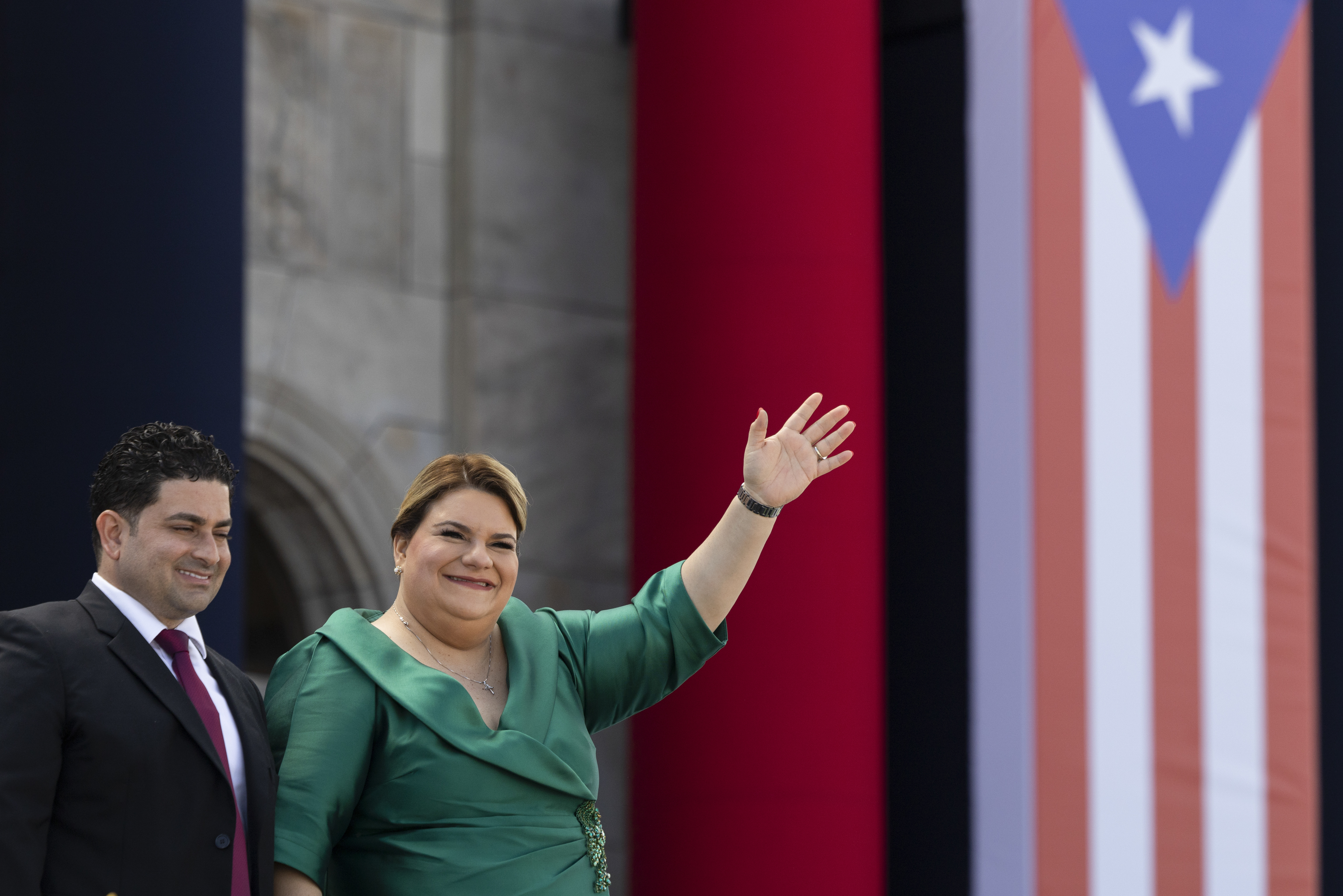 Jenniffer Gonzalez Colon waves alongside her husband Jose Yovin Vargas during her swearing-in ceremony as governor outside the Capitol in San Juan, Puerto Rico, Thursday, Jan. 2, 2025. (AP Photo/Alejandro Granadillo)