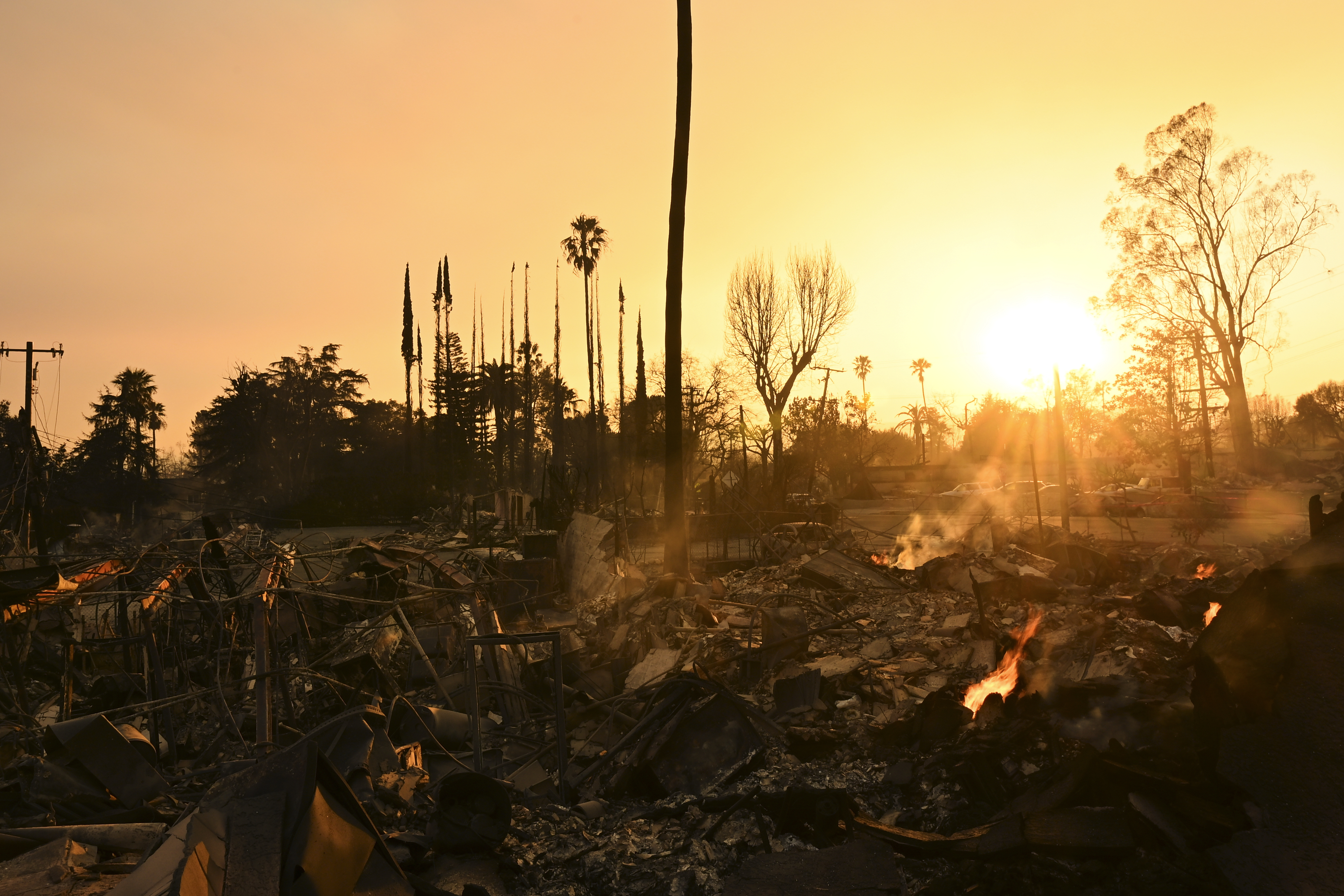 The sun sets over damage from the Eaton Fire, Thursday, Jan. 9, 2025, in Altadena, Calif. (AP Photo/Nic Coury)