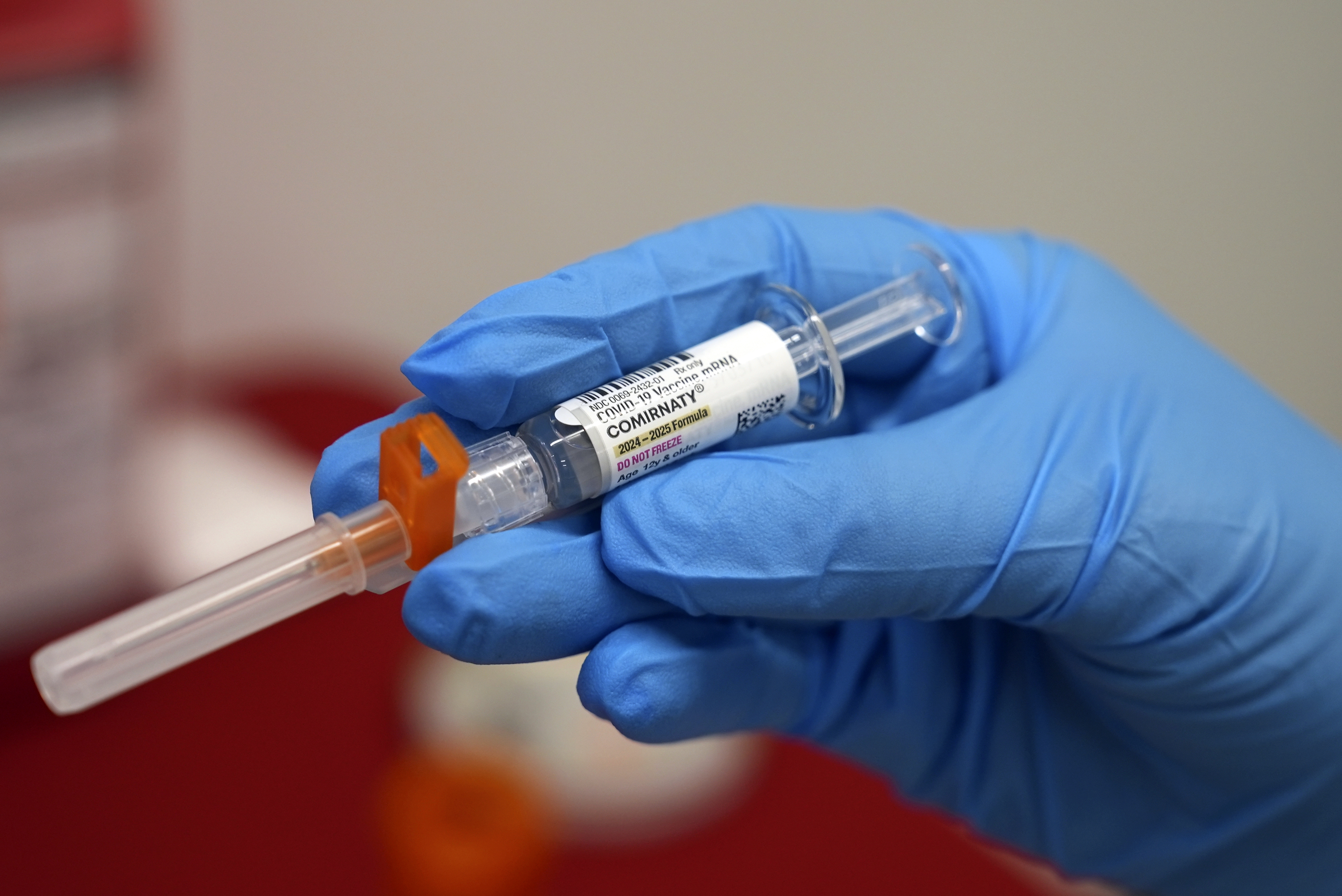 FILE - A pharmacist holds a COVID-19 vaccine at a pharmacy in New York, on Sept. 24, 2024. (AP Photo/Mary Conlon, File)