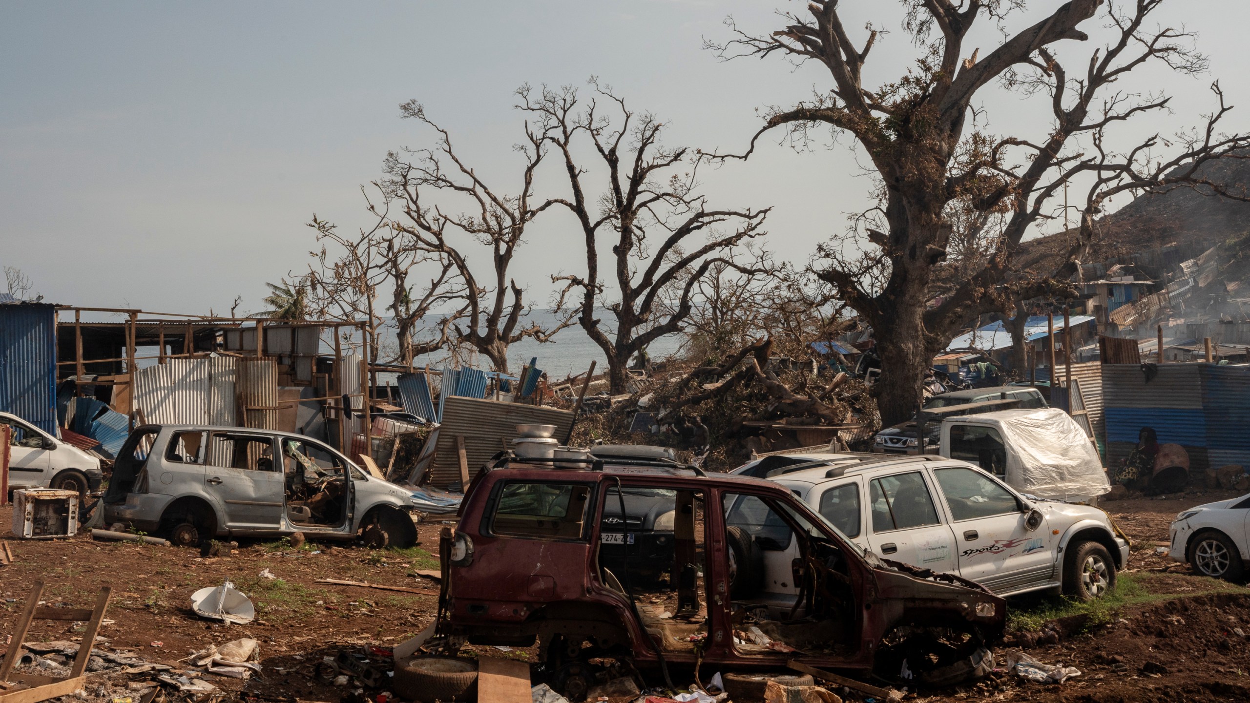 Broken cars are seen in Barakani, Mayotte, France on Saturday, Dec. 21, 2024. (AP Photo/Adrienne Surprenant)