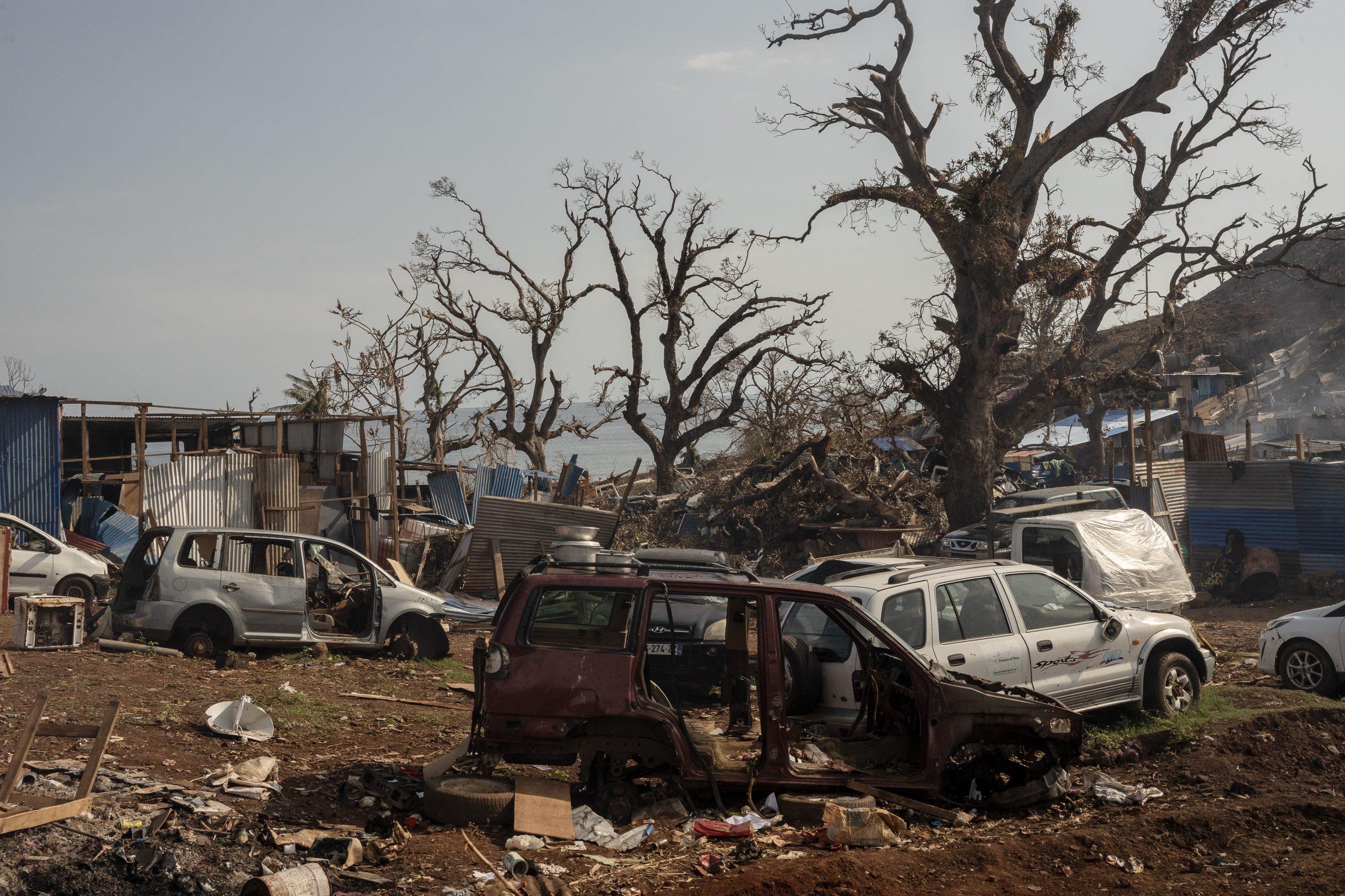 Broken cars are seen in Barakani, Mayotte, France on Saturday, Dec. 21, 2024. (AP Photo/Adrienne Surprenant)