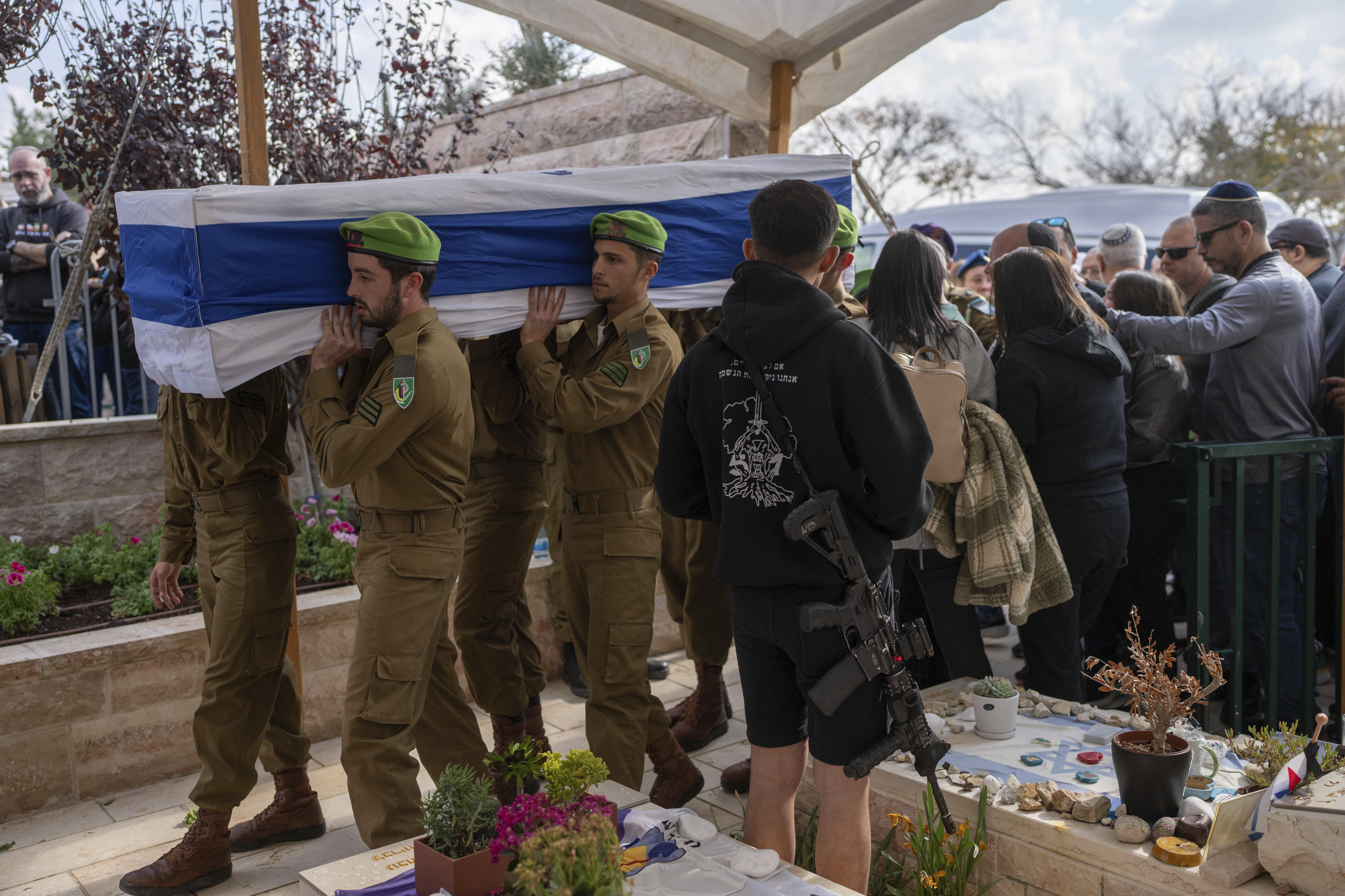 Israeli soldiers and relatives carry the flag-draped casket of Sergeant Yahav Maayan, who was killed in combat in the Gaza Strip, during his funeral at a military cemetery in Modiin, Israel, Sunday, Jan. 12, 2025. (AP Photo/Ohad Zwigenberg)