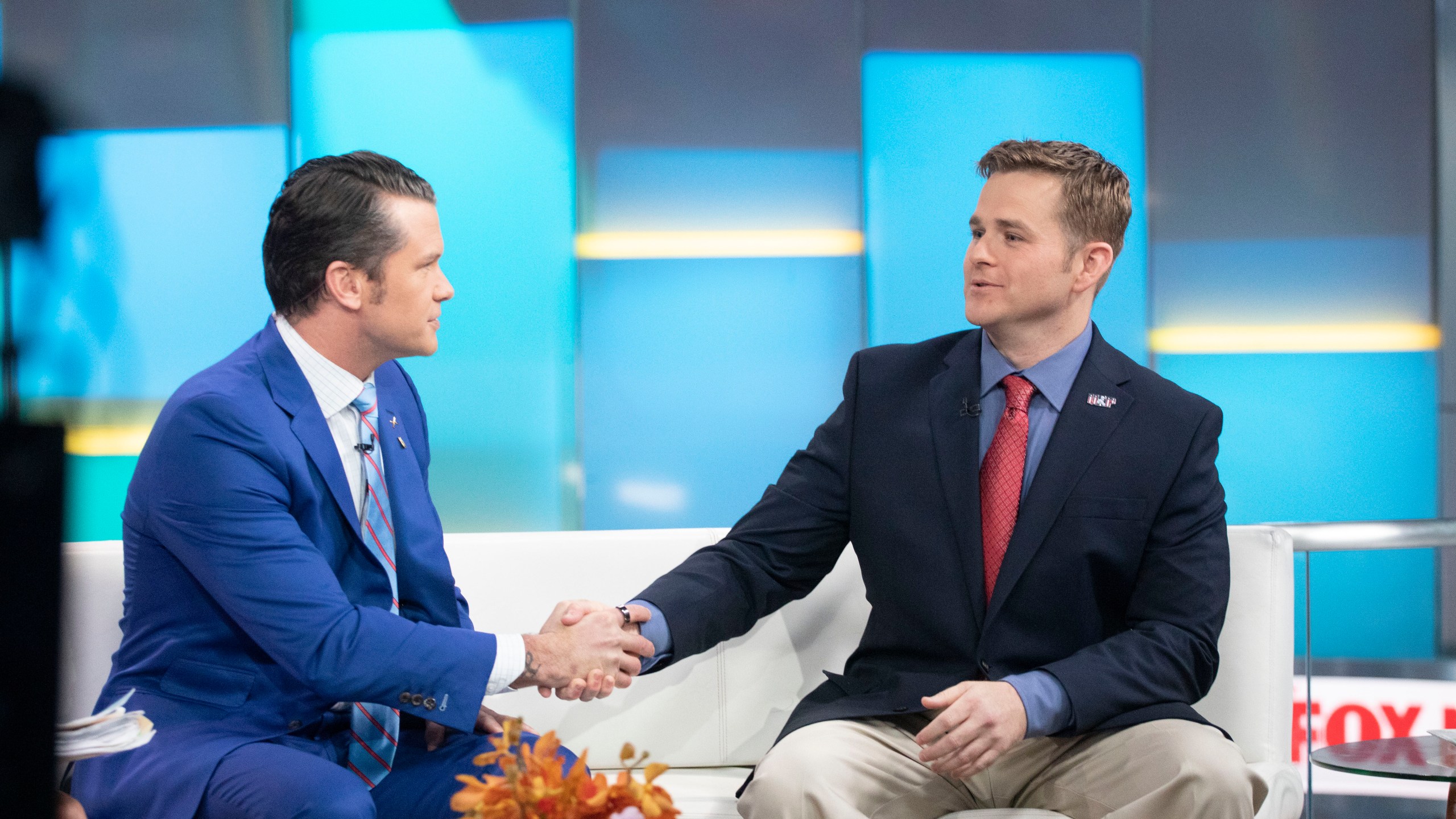 FILE - Pete Hegseth, left, with Fox News, shakes hands with Army 1st Lt. Clint Lorance during his appearance on "Fox & Friends," Nov. 18, 2019, in New York. President Donald Trump issued a full pardon Friday, Nov. 15 for Lorance, who had been convicted of murder for ordering his soldiers to fire upon three unarmed Afghan men in July 2012, killing two. (AP Photo/Mark Lennihan, File)