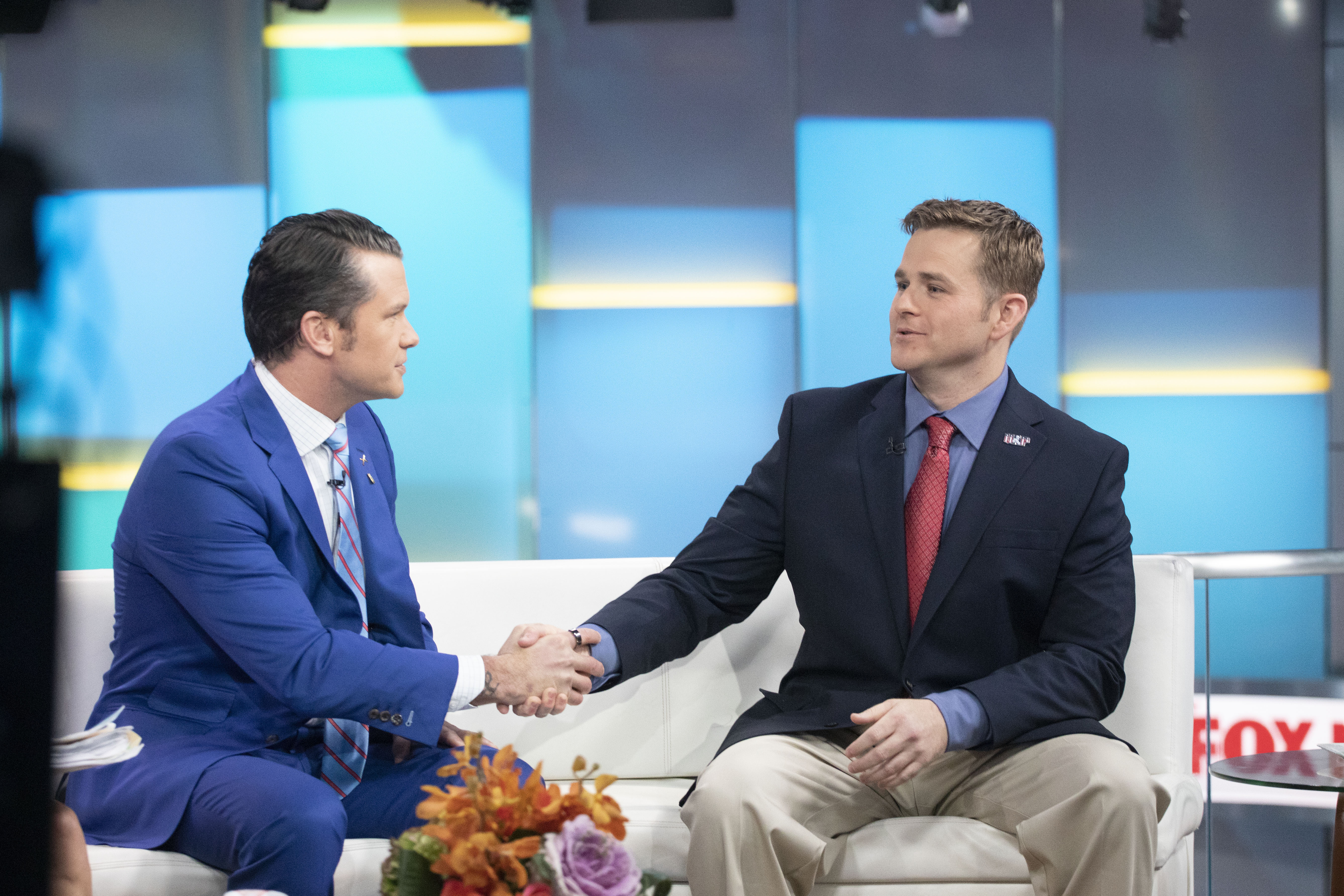 FILE - Pete Hegseth, left, with Fox News, shakes hands with Army 1st Lt. Clint Lorance during his appearance on "Fox & Friends," Nov. 18, 2019, in New York. President Donald Trump issued a full pardon Friday, Nov. 15 for Lorance, who had been convicted of murder for ordering his soldiers to fire upon three unarmed Afghan men in July 2012, killing two. (AP Photo/Mark Lennihan, File)