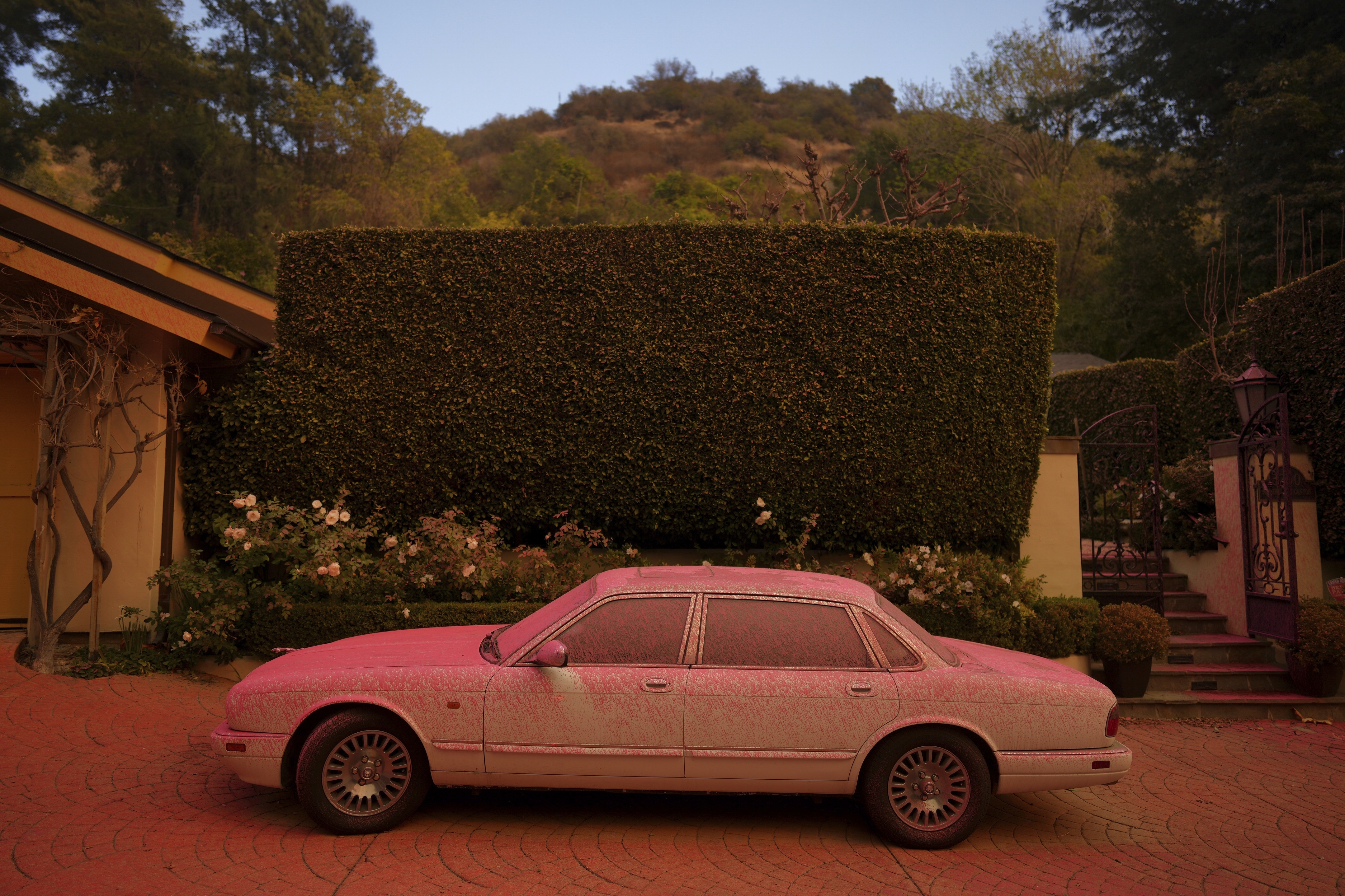 FILE - A vehicle is covered in fire retardant while crews battle the Palisades Fire in Mandeville Canyon on Jan. 11, 2025, in Los Angeles. (AP Photo/Eric Thayer, File)