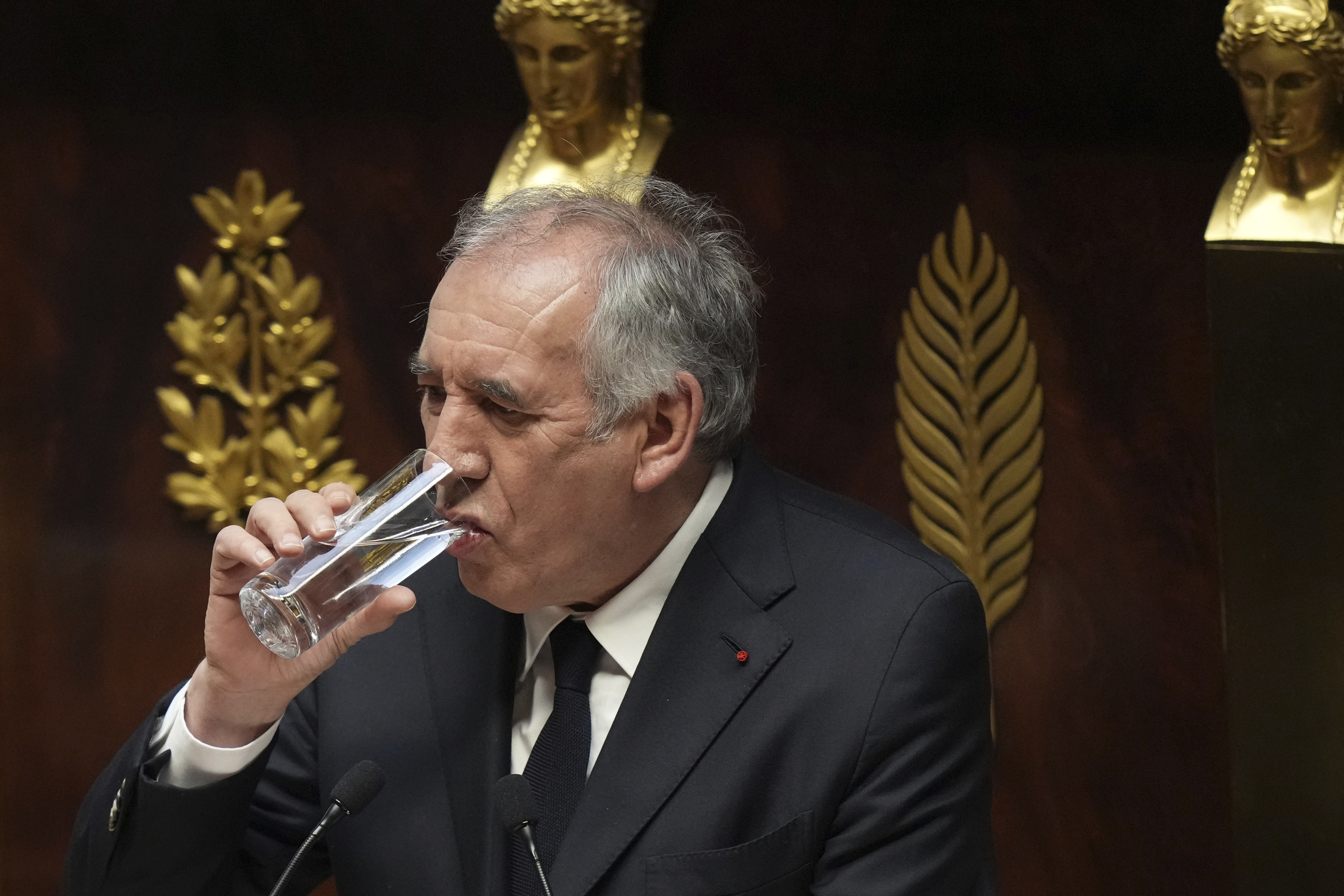 French Prime Minister Francois Bayrou drinks as he delivers his general policy speech, Tuesday, Jan. 14, 2025 at the National Assembly in Paris. (AP Photo/Thibault Camus)