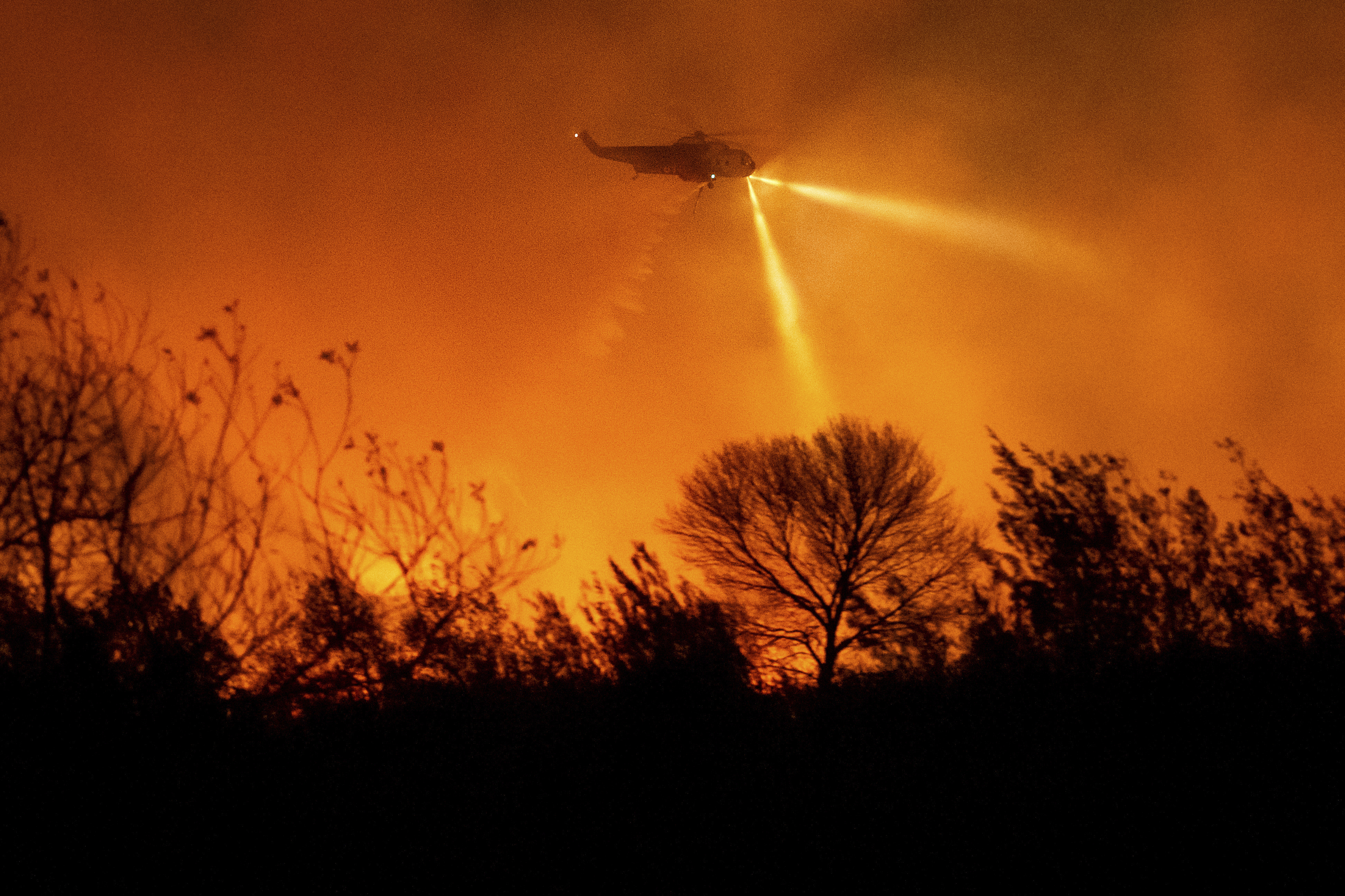 A helicopter drops water while fighting the Auto Fire in Ventura County, Calif., on Monday, Jan. 13, 2025. (AP Photo/Noah Berger)