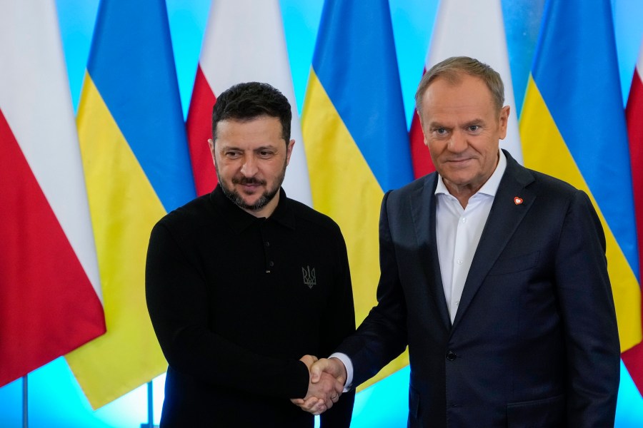 Polish Prime Minister Donald Tusk, right, welcomes Ukrainian President Volodymyr Zelenskyy after the two countries reached an agreement on exhuming Polish victims of WWII-era massacres by Ukrainian nationalists, in Warsaw, Poland, on Wednesday, Jan. 15, 2025. (AP Photo/Czarek Sokolowski)