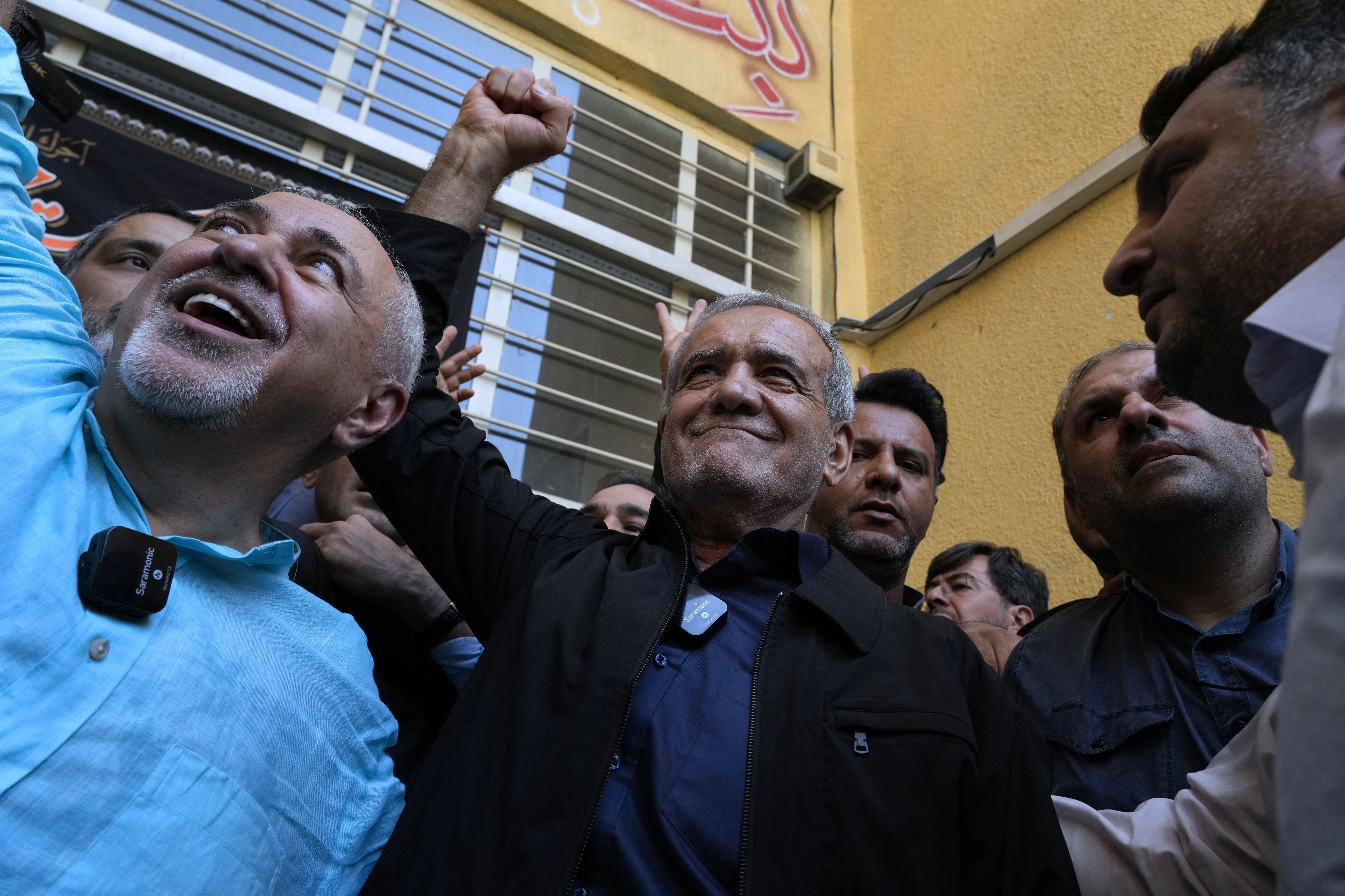 FILE - Reformist candidate for the Iran's presidential election Masoud Pezeshkian clenches his fist after casting his vote as he is accompanied by former Foreign Minister Mohammad Javad Zarif, left, at a polling station in Shahr-e-Qods near Tehran, Iran, Friday, July 5, 2024. (AP Photo/Vahid Salemi, File)