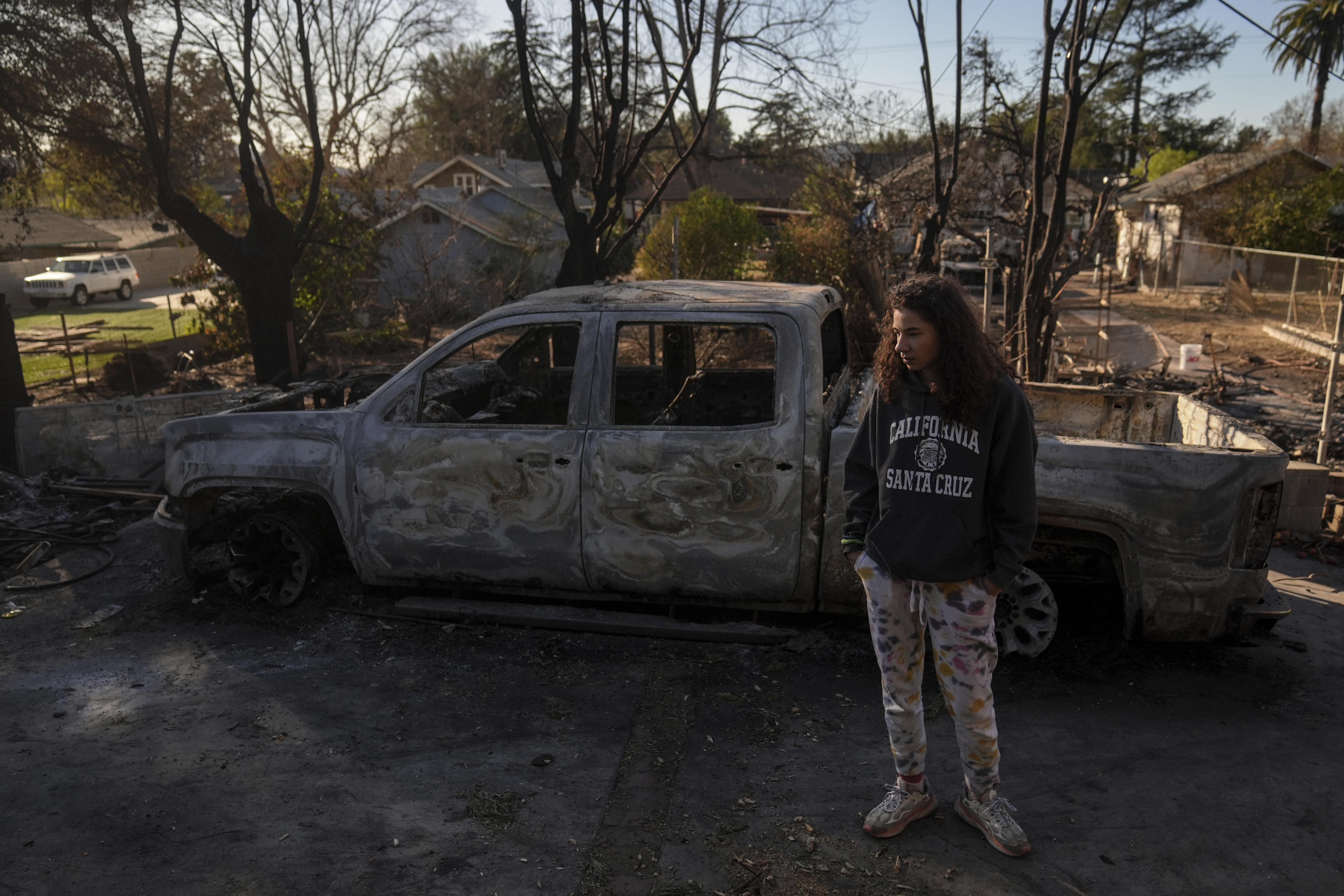 Kaylin Johnson, whose home is one of the few that survived the Eaton Fire in her neighborhood in Altadena, Calif., visits her neighbor's home Tuesday, Jan. 14, 2025. (AP Photo/Jae C. Hong)