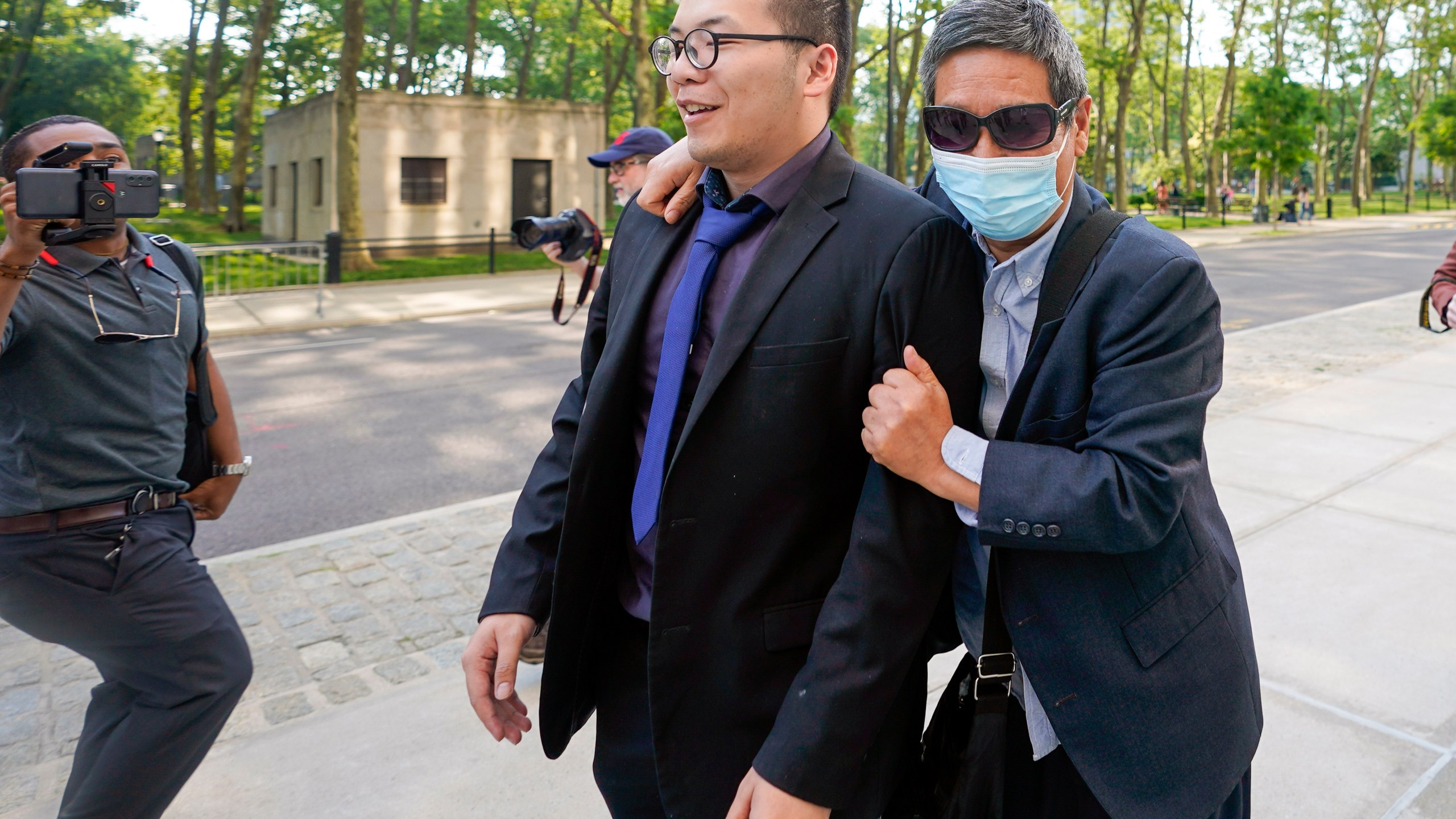 FILE - Zhu Yong, right, tries to shield himself from photographers as he leaves federal court, May 31, 2023, in the Brooklyn borough of New York. (AP Photo/Mary Altaffer, File)