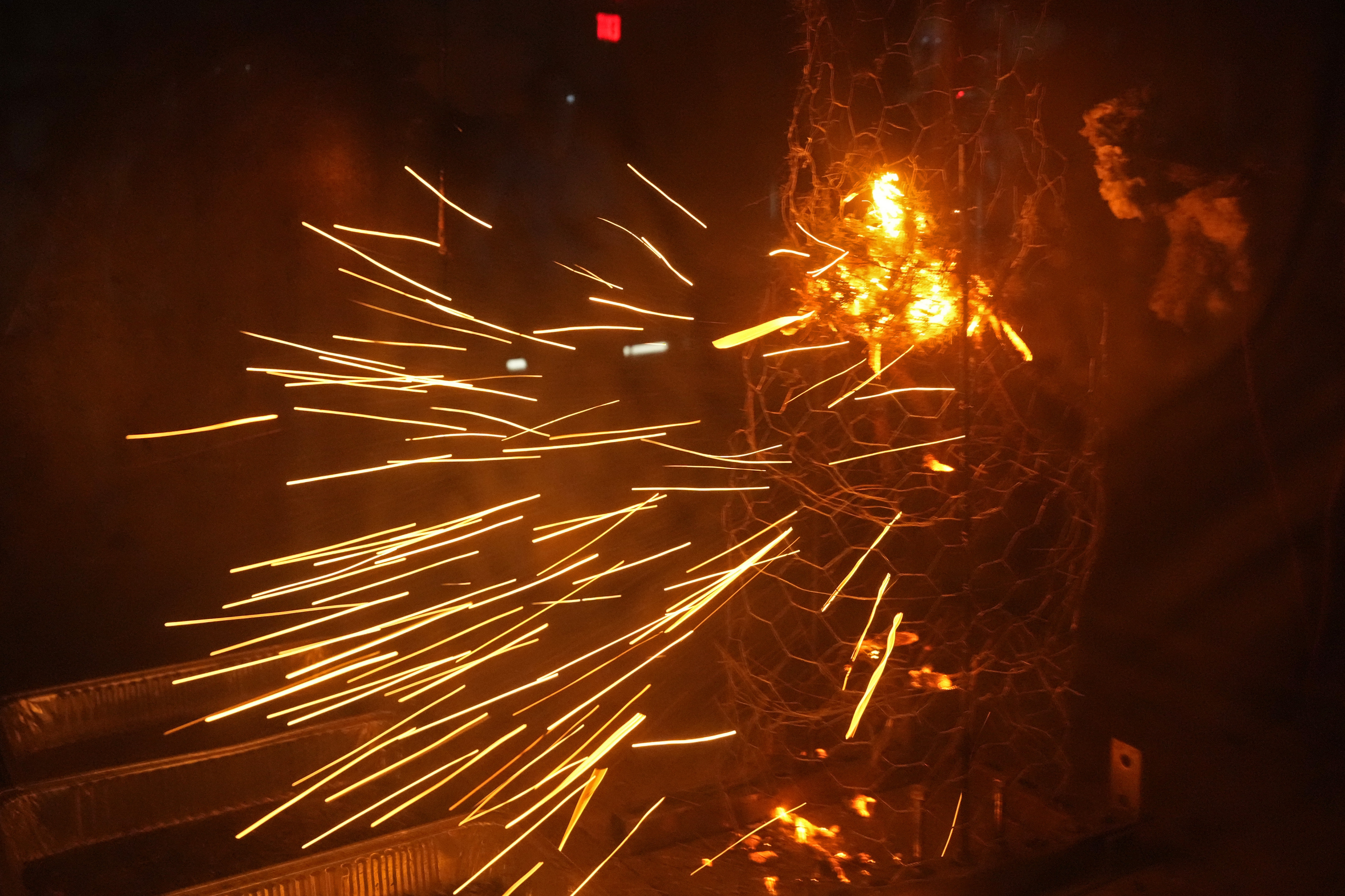 Sparks fly during a controlled burning of brush in a wind tunnel in lab at Worcester Polytechnic Institute, Wednesday, Jan. 15, 2025, in Worcester, Mass. (AP Photo/Robert F. Bukaty)