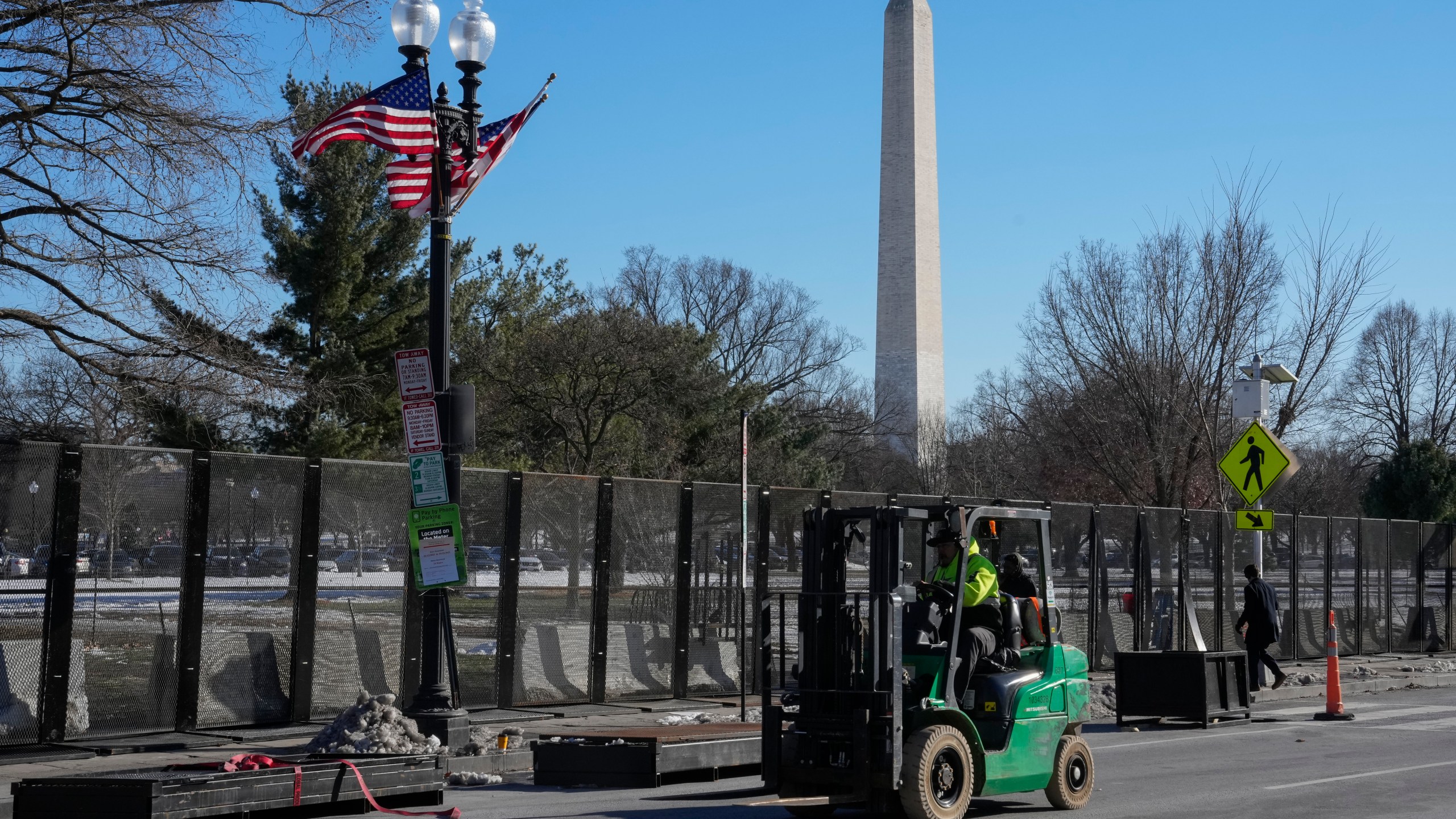 Workers install security fencing around the Ellipse near the White House ahead of the upcoming inauguration of President-elect Donald Trump in Washington, Tuesday, Jan. 14, 2025. (AP Photo/Jon Elswick)