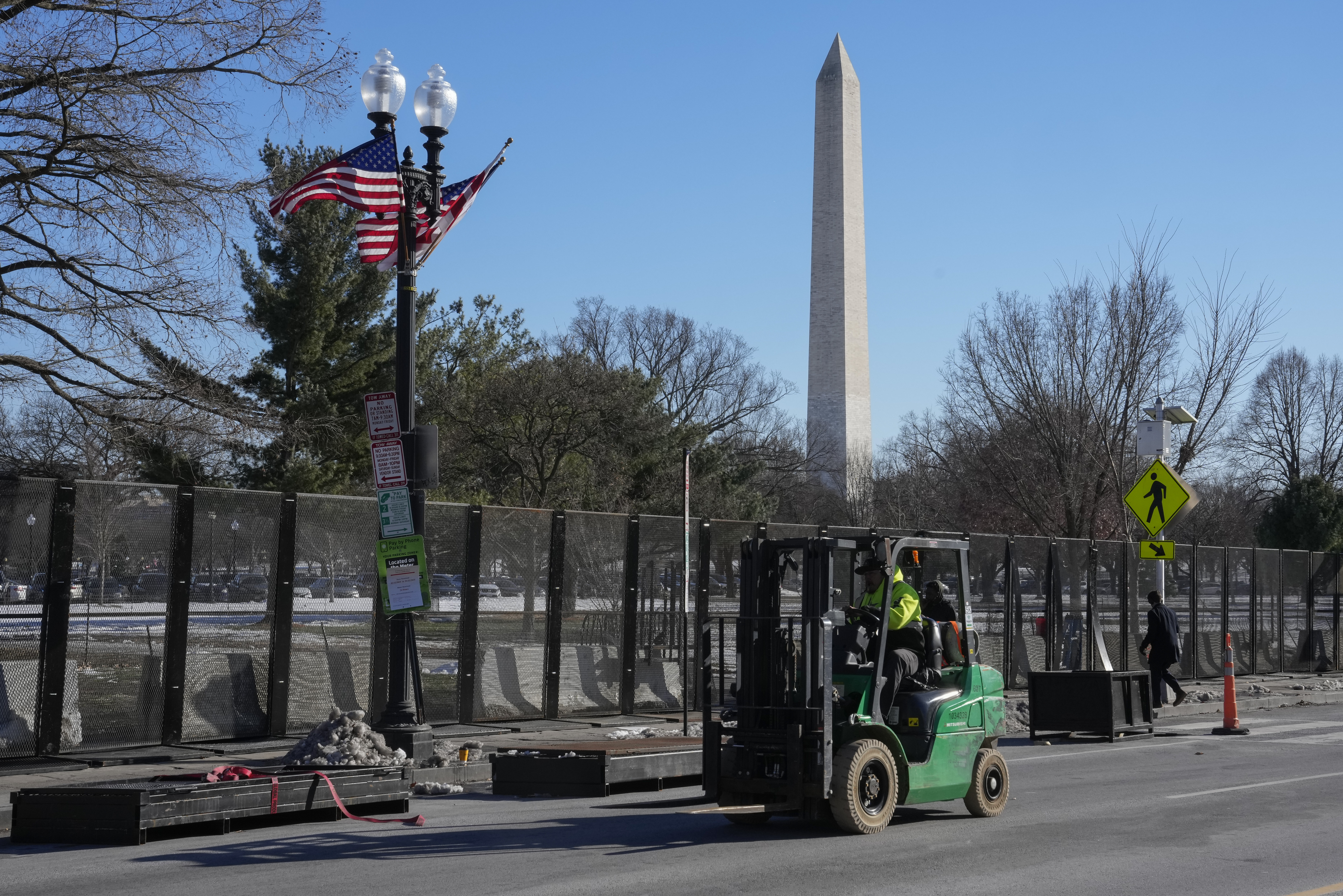 Workers install security fencing around the Ellipse near the White House ahead of the upcoming inauguration of President-elect Donald Trump in Washington, Tuesday, Jan. 14, 2025. (AP Photo/Jon Elswick)