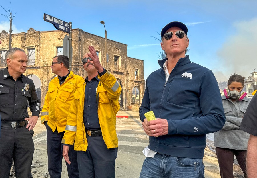 California Governor Gavin Newsom, right, surveys damage in Pacific Palisades with CalFire's Nick Schuler during the Palisades Fire on Wednesday, Jan. 8, 2025, in Pacific Palisades, Calif. (Jeff Gritchen/The Orange County Register via AP)