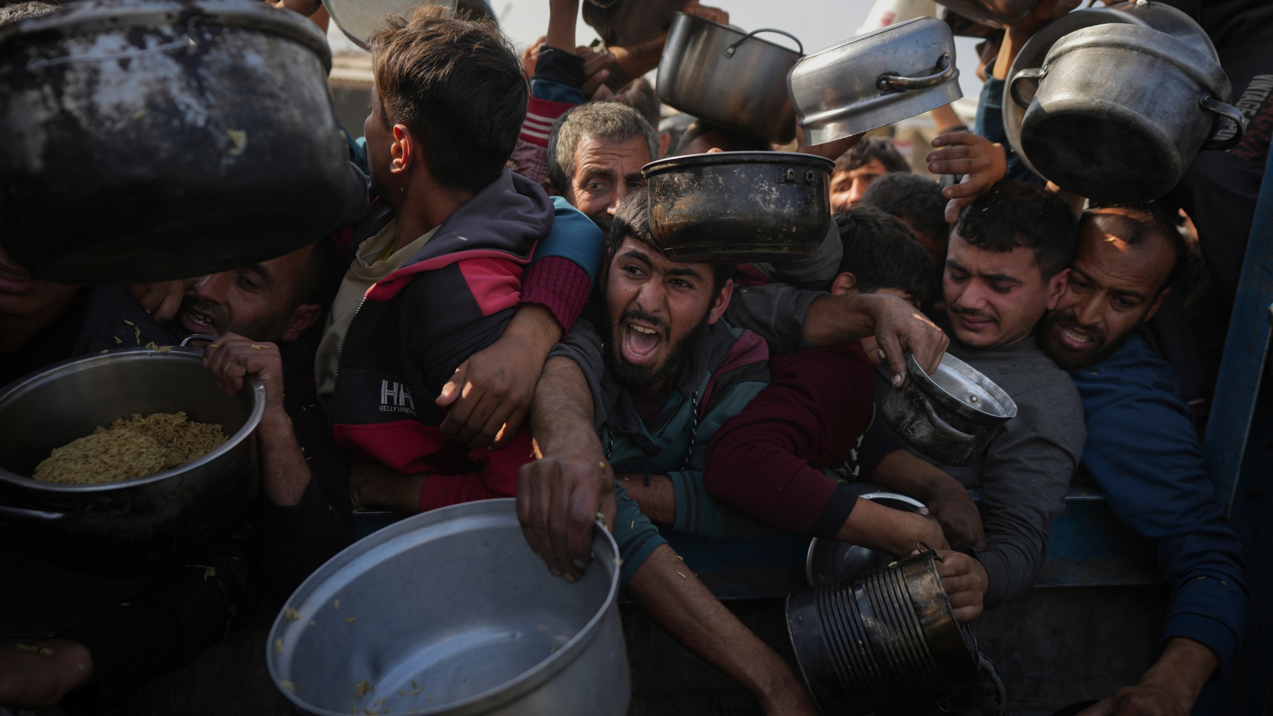 FILE - Palestinians struggle for food at a distribution center in Khan Younis, Gaza Strip, Jan. 9, 2025. (AP Photo/Abdel Kareem Hana, File)