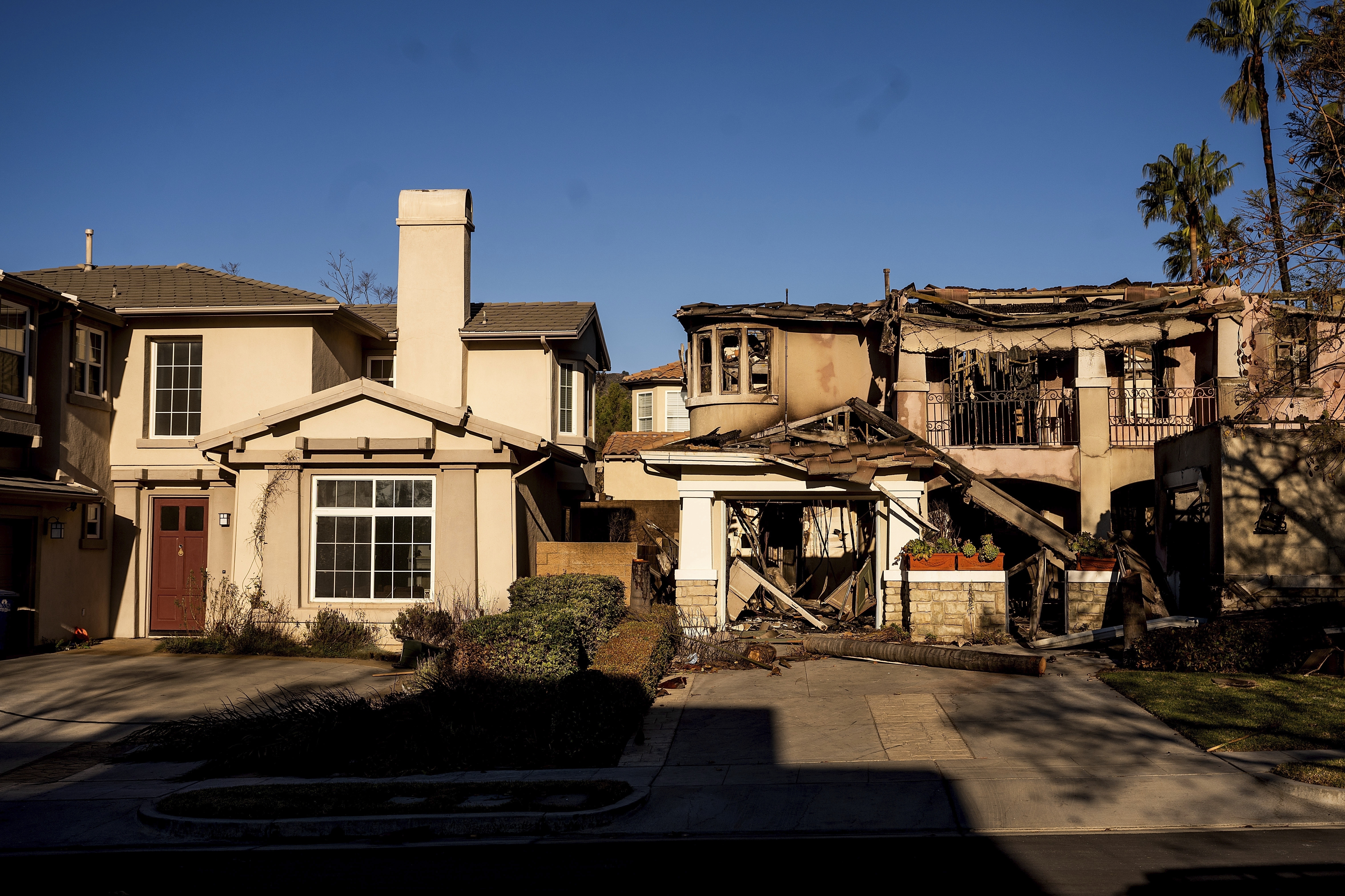 FILE - A home destroyed by the Eaton Fire, right, stands next a home that survived in Altadena. Calif., on Monday, Jan. 13, 2025. (AP Photo/Noah Berger, File)