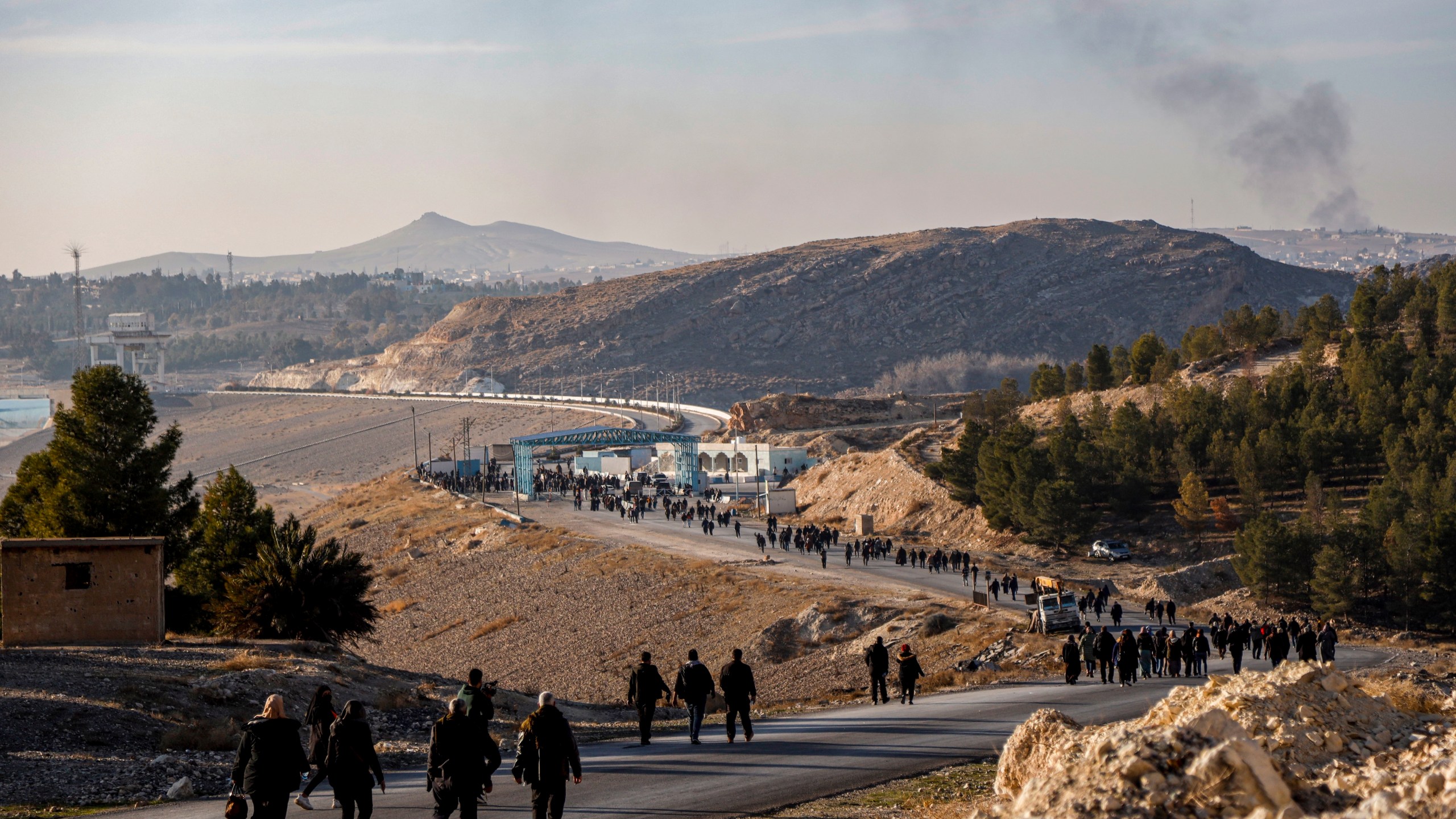 Residents of northeastern Syria walk towards the Tishrin Dam to join a sit-in demanding an end to the war in the region in Aleppo's countryside, Syria, Wednesday Jan. 8, 2025. The Tishrin Dam has become a flashpoint in the conflict between Kurdish forces and Turkish-backed armed groups, which has intensified in the weeks since the fall of former Syrian President Bashar Assad in a lightning offensive.(AP Photo/Baderkhan Ahmad)