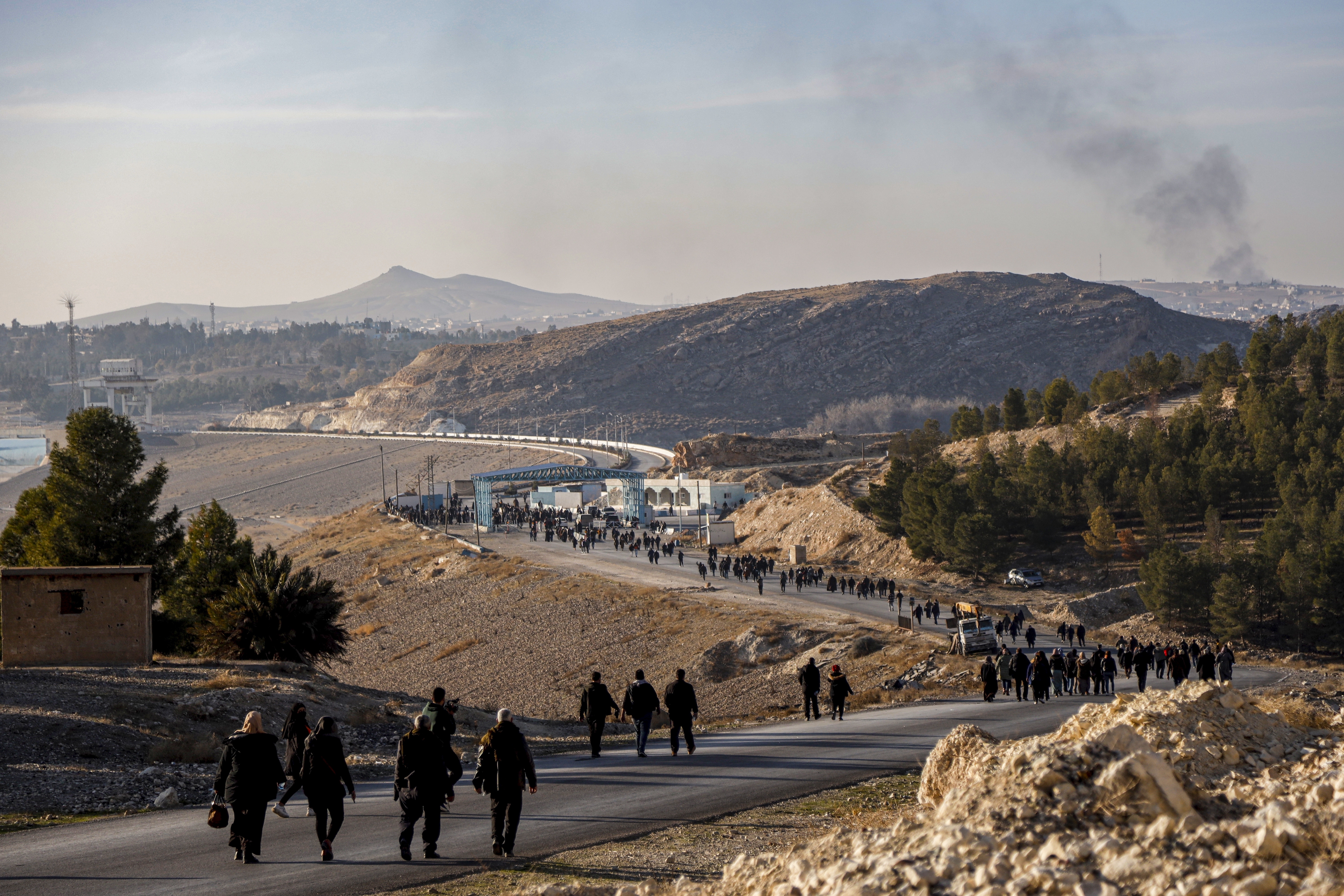 Residents of northeastern Syria walk towards the Tishrin Dam to join a sit-in demanding an end to the war in the region in Aleppo's countryside, Syria, Wednesday Jan. 8, 2025. The Tishrin Dam has become a flashpoint in the conflict between Kurdish forces and Turkish-backed armed groups, which has intensified in the weeks since the fall of former Syrian President Bashar Assad in a lightning offensive.(AP Photo/Baderkhan Ahmad)