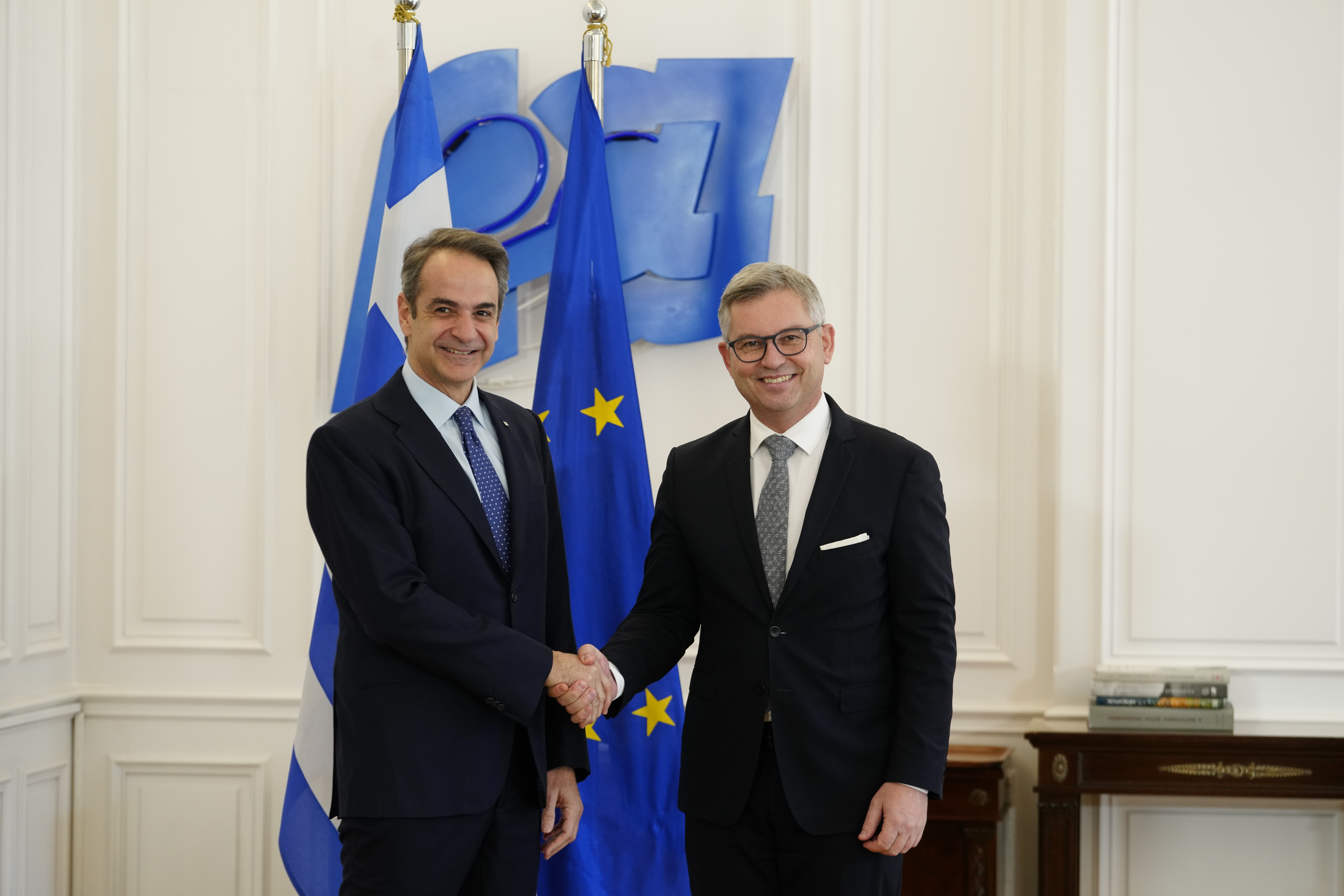 The European Union's new commissioner for migration, Magnus Brunner, right, shakes hands with Greece's Prime Minister Kyriakos Mitsotakis before their discussions on Europe's migration pact and border protections in Athens, Thursday, Jan. 16, 2025. (AP Photo/Petros Giannakouris)