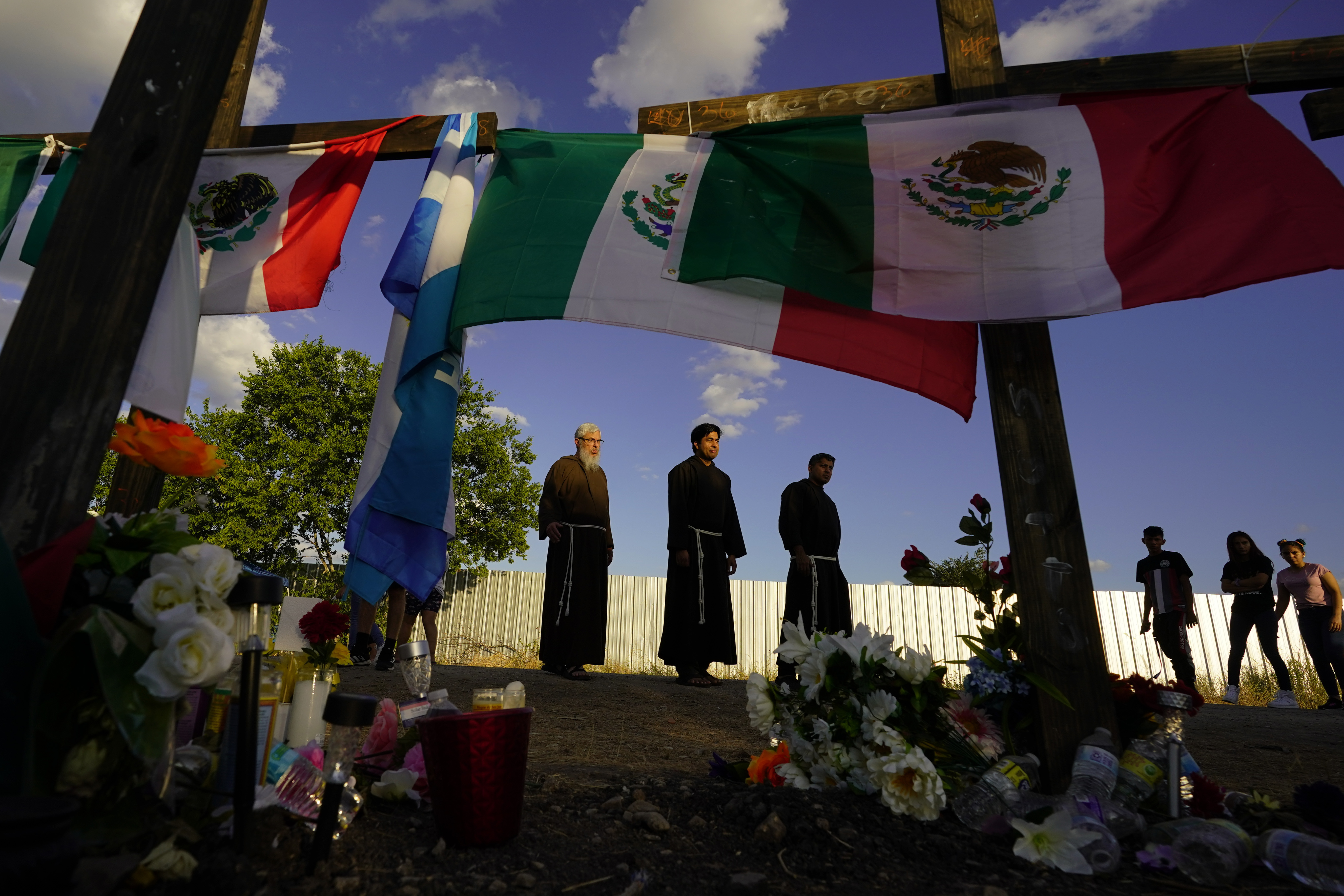 FILE - People visit a makeshift memorial honoring the victims and survivors of a human smuggling tragedy, where dozens of migrants were found in an airless tractor-trailer rig, in San Antonio, July 6, 2022. (AP Photo/Eric Gay, File)