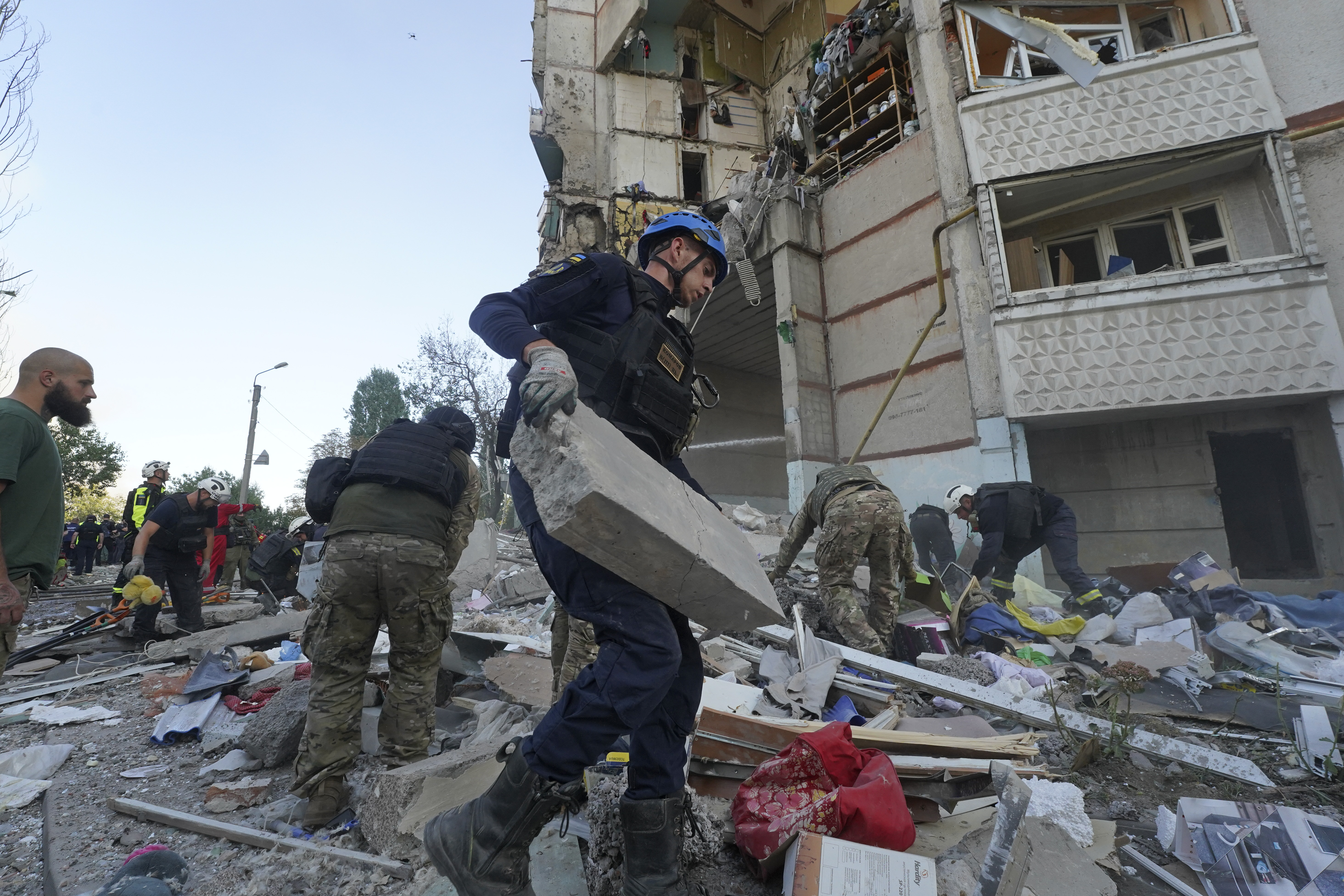 FILE - Emergency workers and soldiers try to shift the rubble and debris after a Russian attack that hit a residential building in Kharkiv, Ukraine, Tuesday Sept. 24, 2024. (AP Photo/Andrii Marienko, File)