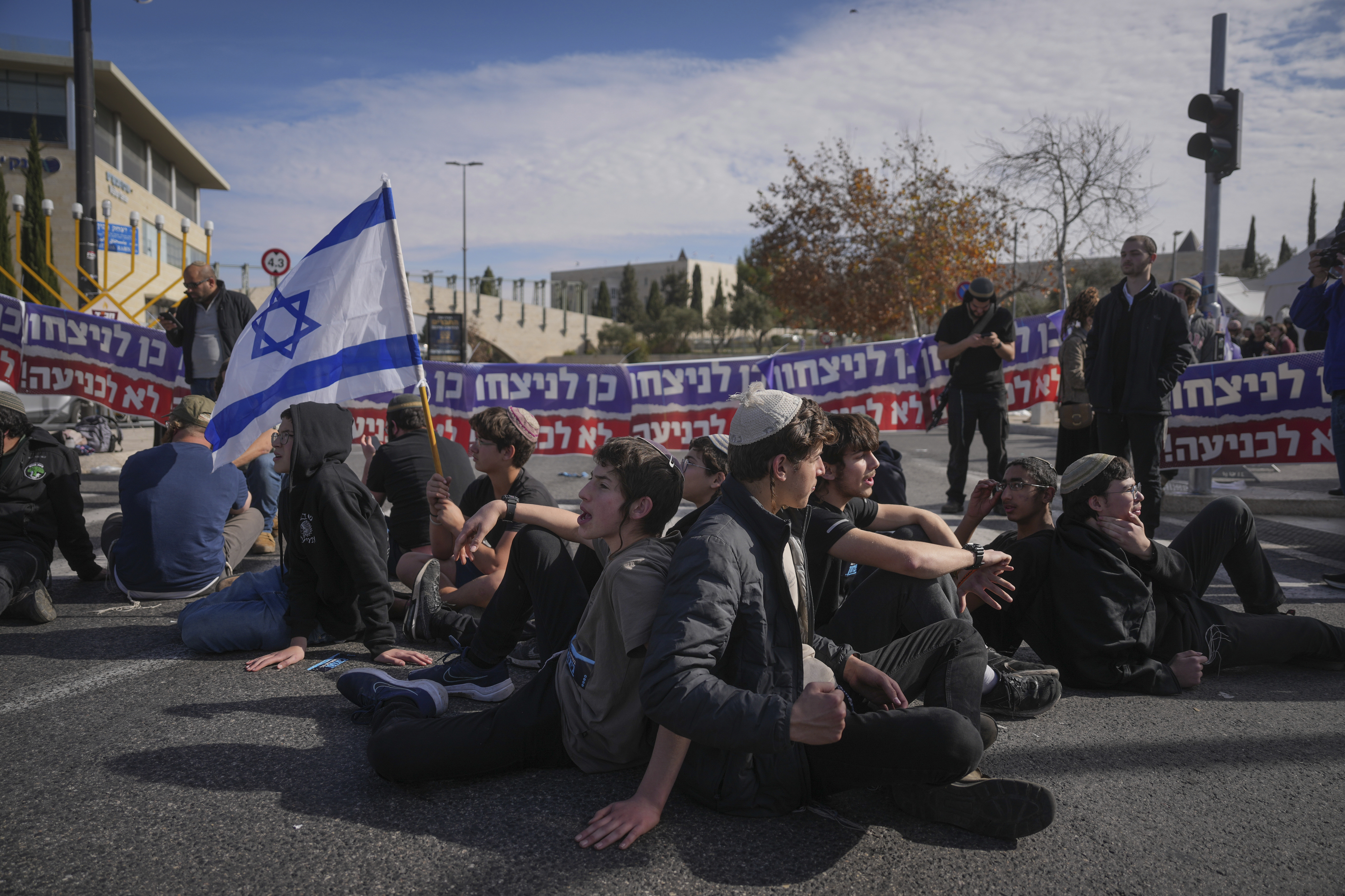 Activists representing families of Israelis who were killed during the war in Gaza block a road during a protest against the ceasefire deal between Israel and Hamas in Jerusalem on Thursday, Jan. 16, 2025. (AP Photo/Ohad Zwigenberg)